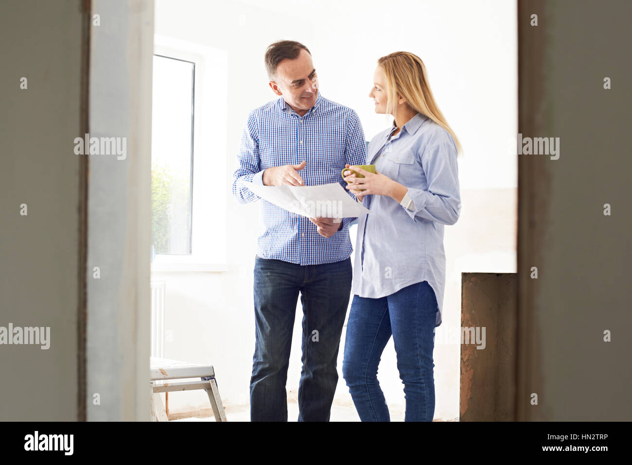 Frau treffen mit Architekt oder Baumeister In renovierten Anwesen Stockfoto