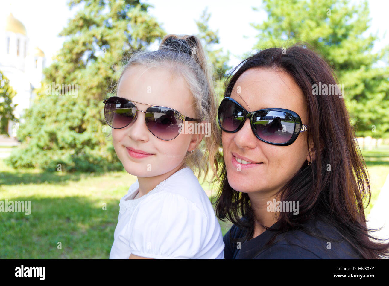 Foto von lächelnden Mutter und Tochter in Sonnenbrillen Stockfoto