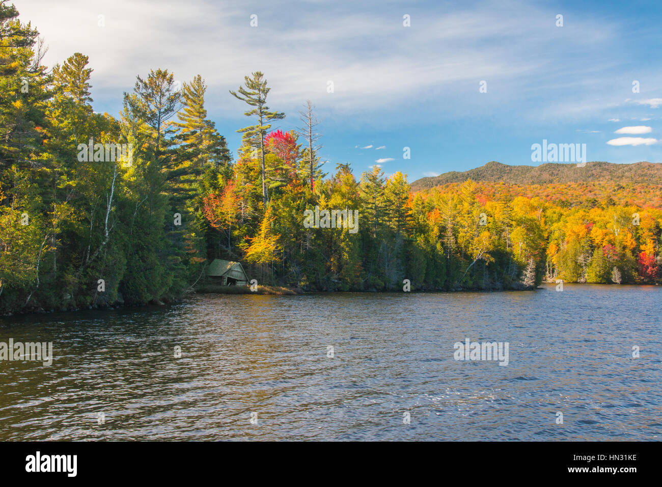 Bäume zeigen Herbstfärbung und alten Bootshaus Elk See entlang im Adirondack Park, Teil des New Yorker Forest Preserve in Upstate New York, USA Stockfoto