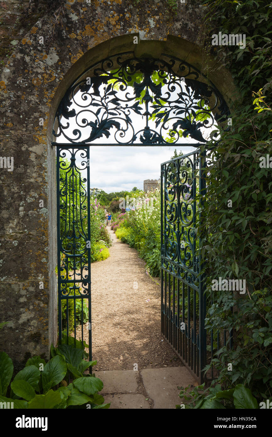 Die dekorative schmiedeeiserne Tor und Cotswold steinernen Torbogen Eingang zu den ummauerten Garten Rousham House. Stockfoto