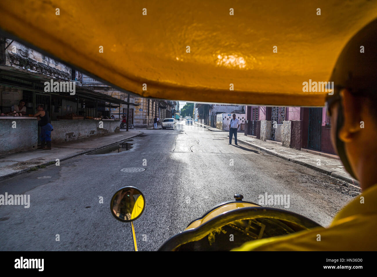 Ein Cocotaxi Fahrer fährt durch die Straßen von Havanna in Kuba. Stockfoto