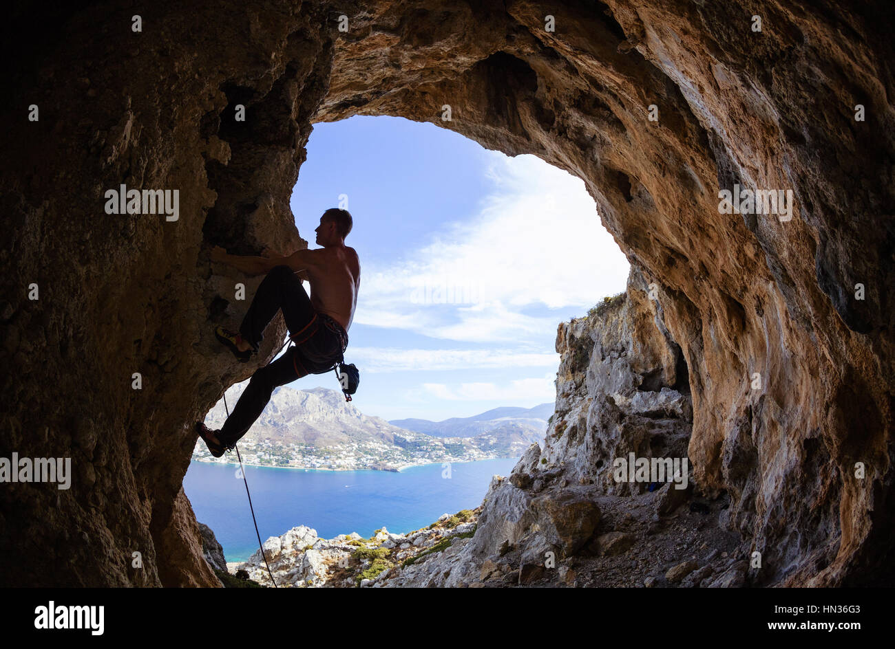 Junger Mann Klettern auf Felsen Stockfoto