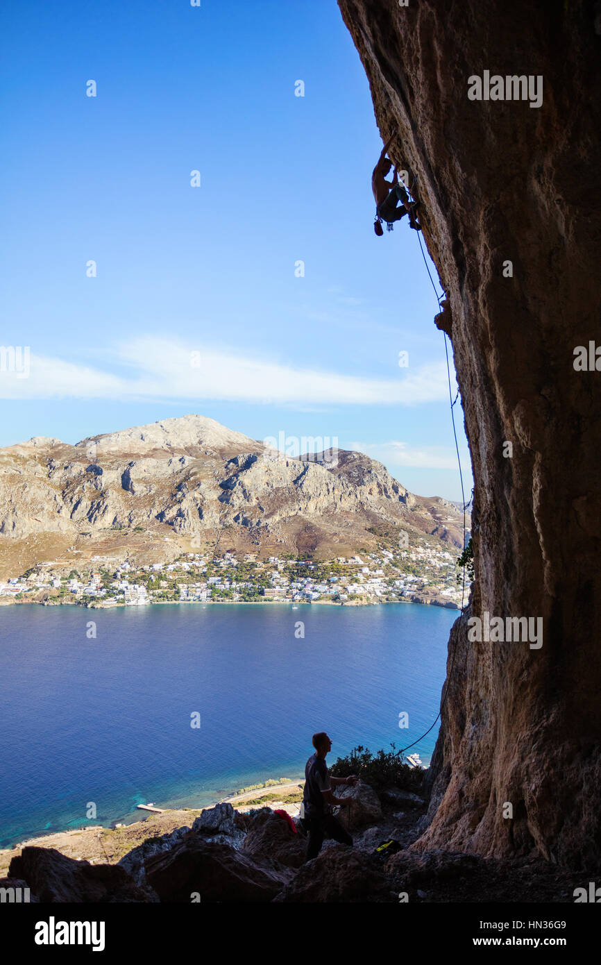 Junger Mann Klettern auf Felsen Stockfoto
