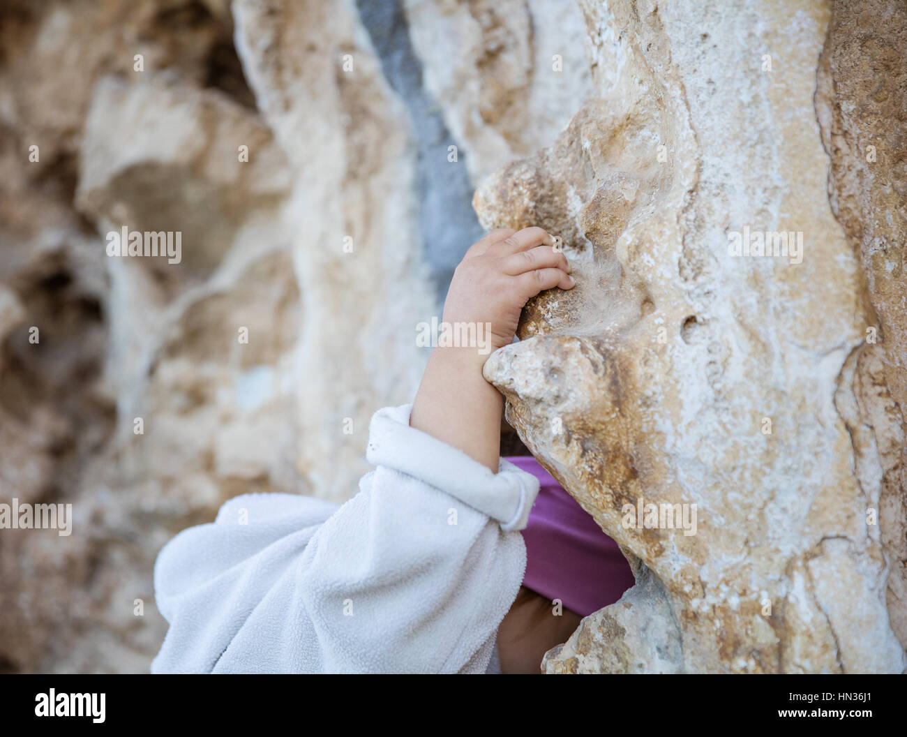 Nahaufnahme von kleinen Mädchen packende Felsen klettern Branche hand im Fokus Stockfoto