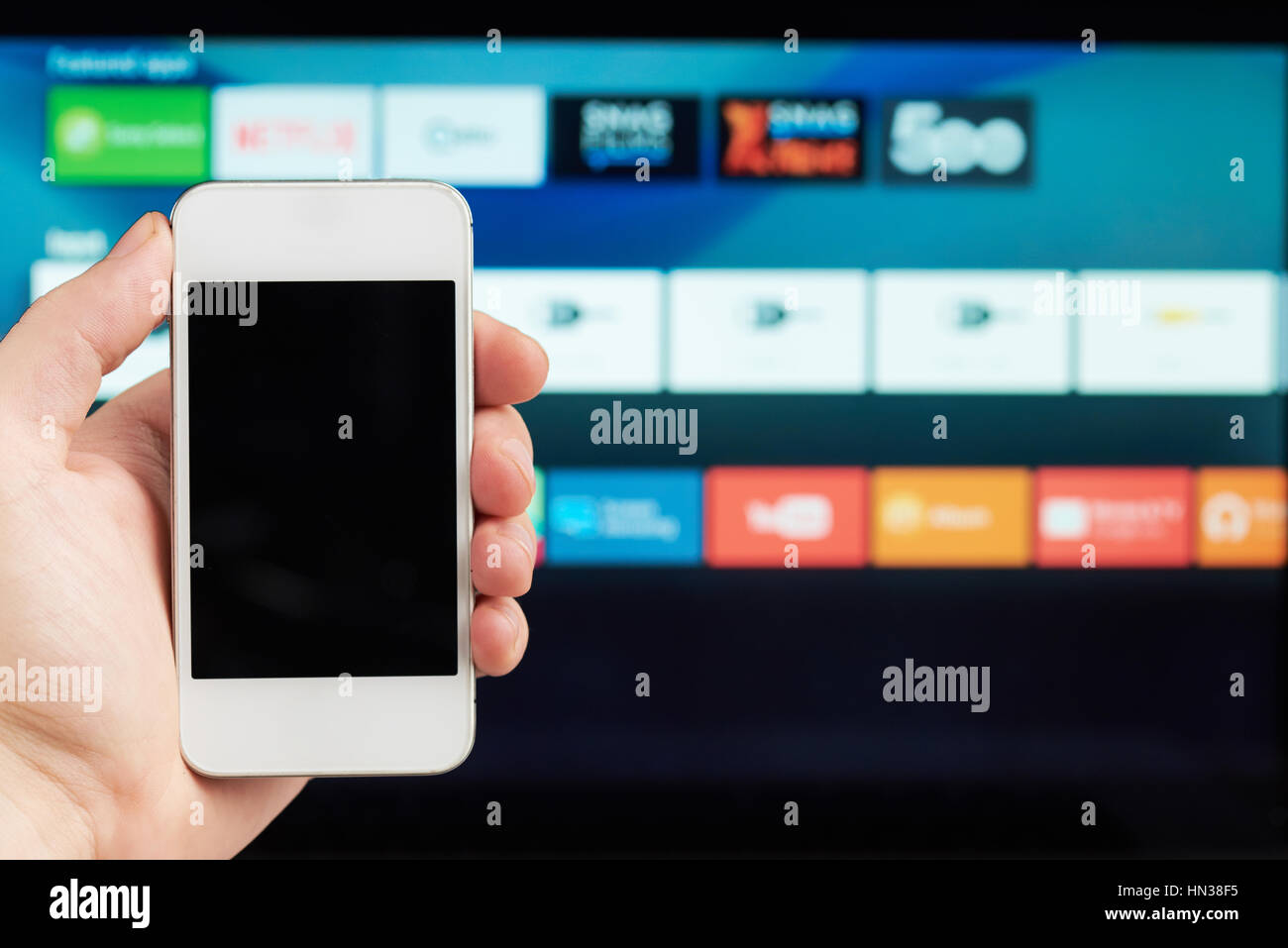 Anschluss von Telefon und smart tv auf unscharfen Hintergrund Stockfoto