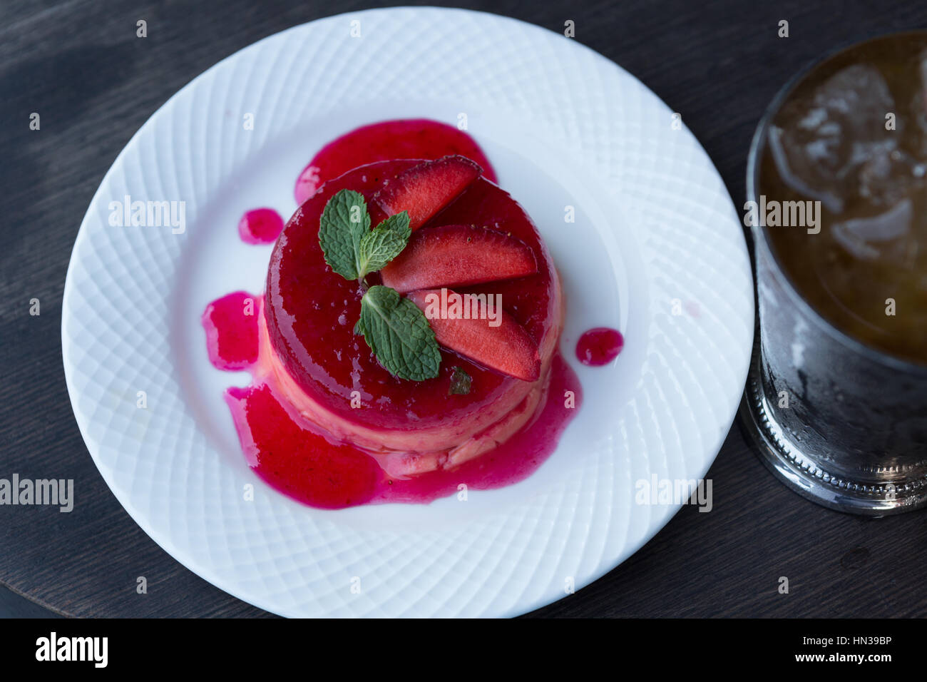 Erdbeer Pudding auf einem weißen Teller auf einem Holztisch Stockfoto