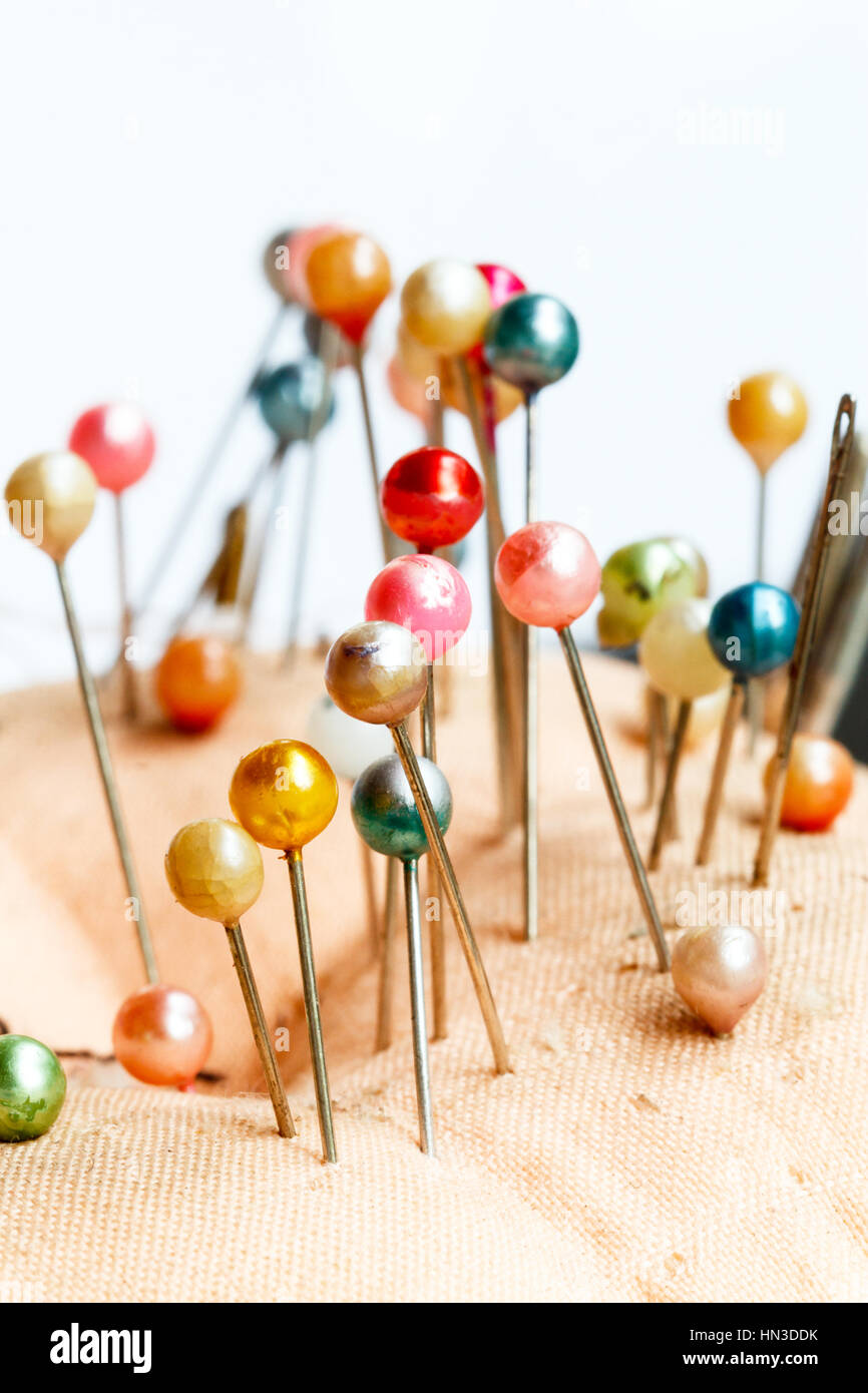 Fabric Nadelkissen mit bunten Stiften auf weißem Hintergrund Stockfoto