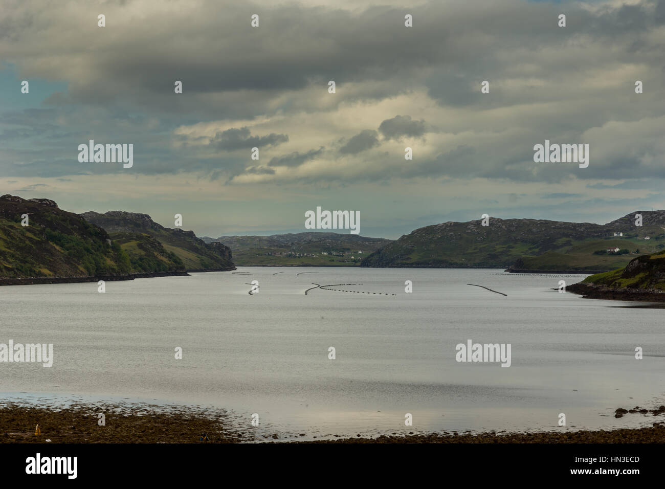 Nordwestküste, Schottland - 6. Juni 2012: Blick über Wasser des Loch Inchard Blick nach Westen während der Dämmerung. Wolkengebilde und schwimmende Markierungen auf der grauen w Stockfoto