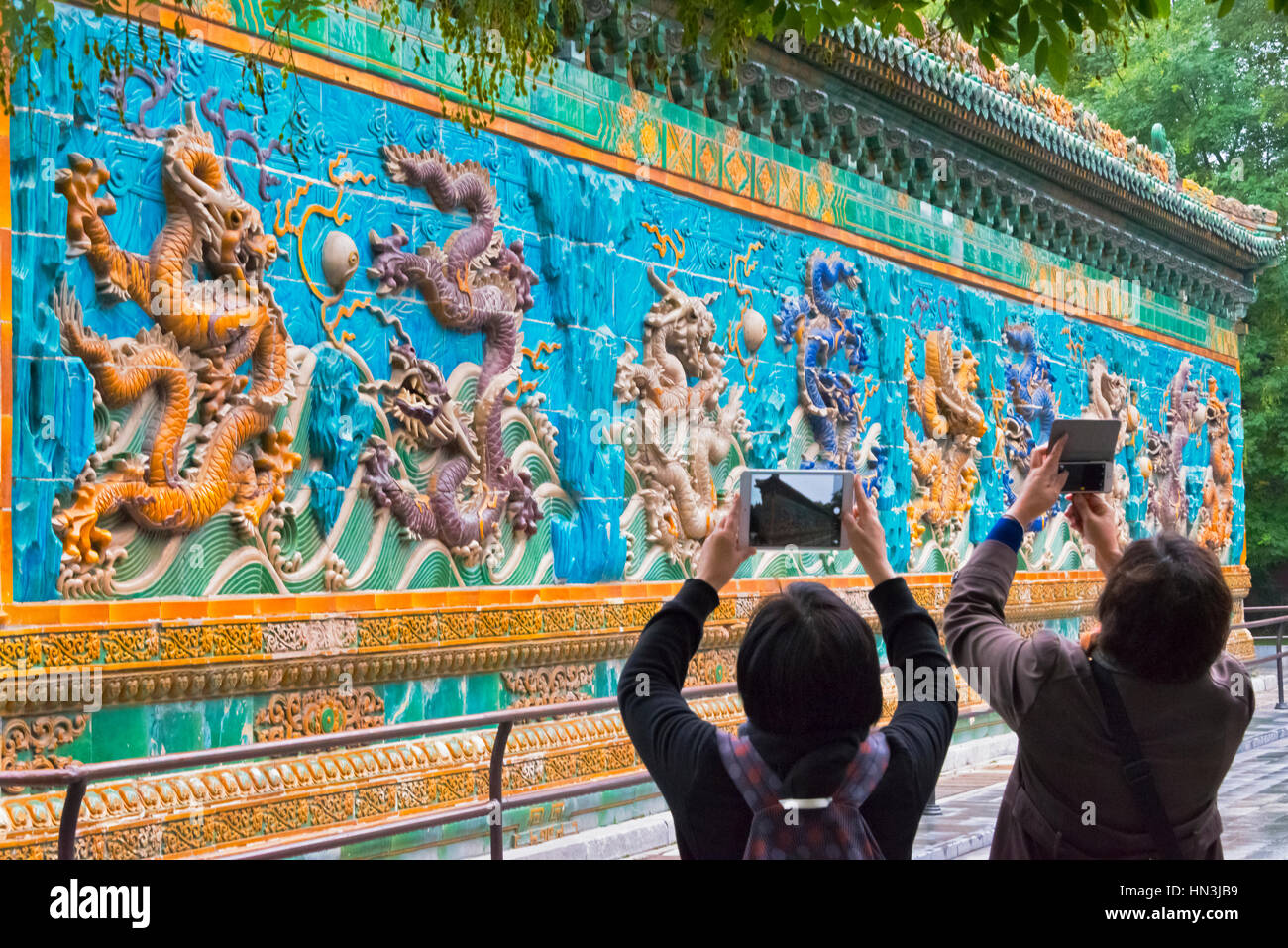 Touristen fotografieren neun Drachen Wand im Beihai-Park, Peking, China Stockfoto