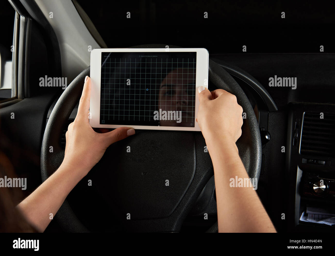 Fahrer-Mädchen mit Tablet für Navigation isoliert auf schwarz Stockfoto