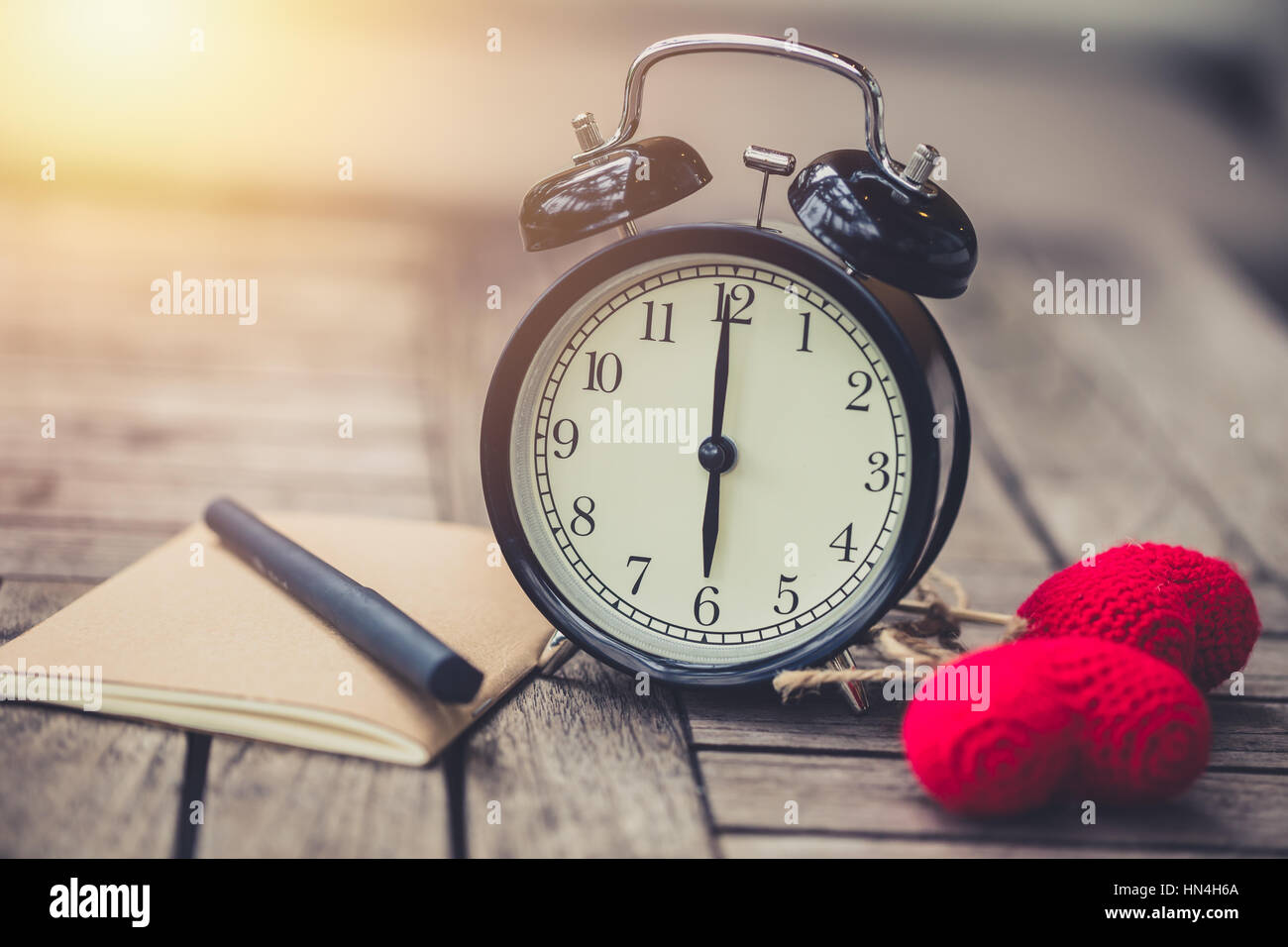 Retro-Uhrzeit um 06:00 mit Notebook oder Memo auf Holztisch, Zeiten der Liebe Erinnerung schreiben Tagebuch Konzept Vintage Farbton. Stockfoto