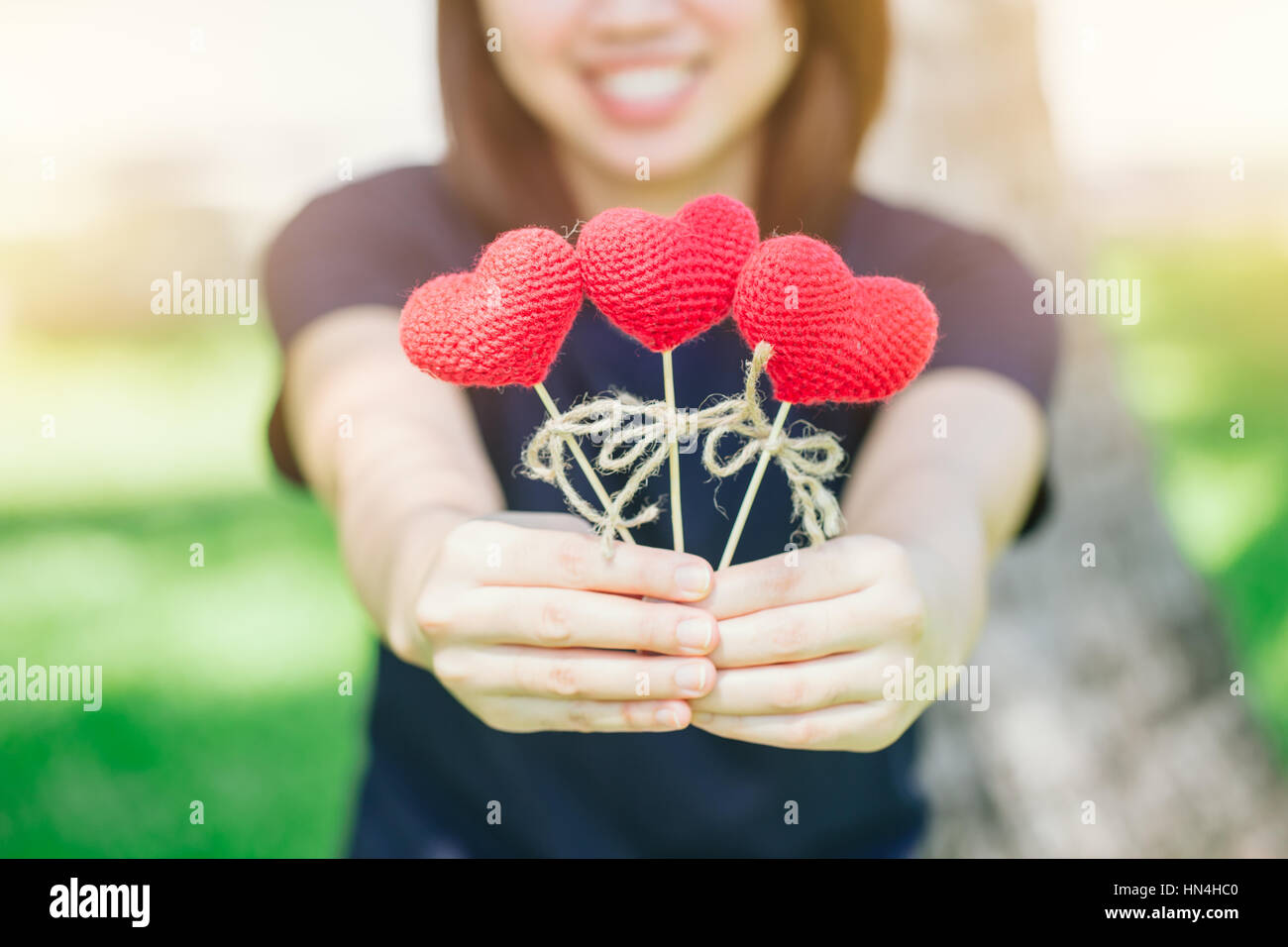 neuen Freund Liebe treffen und Datum süßes Lächeln asiatischen Thai Teen Hand halten rote Herz süße liebevolle Symbol kümmern oder Nächstenliebe helfen Ihnen. Stockfoto