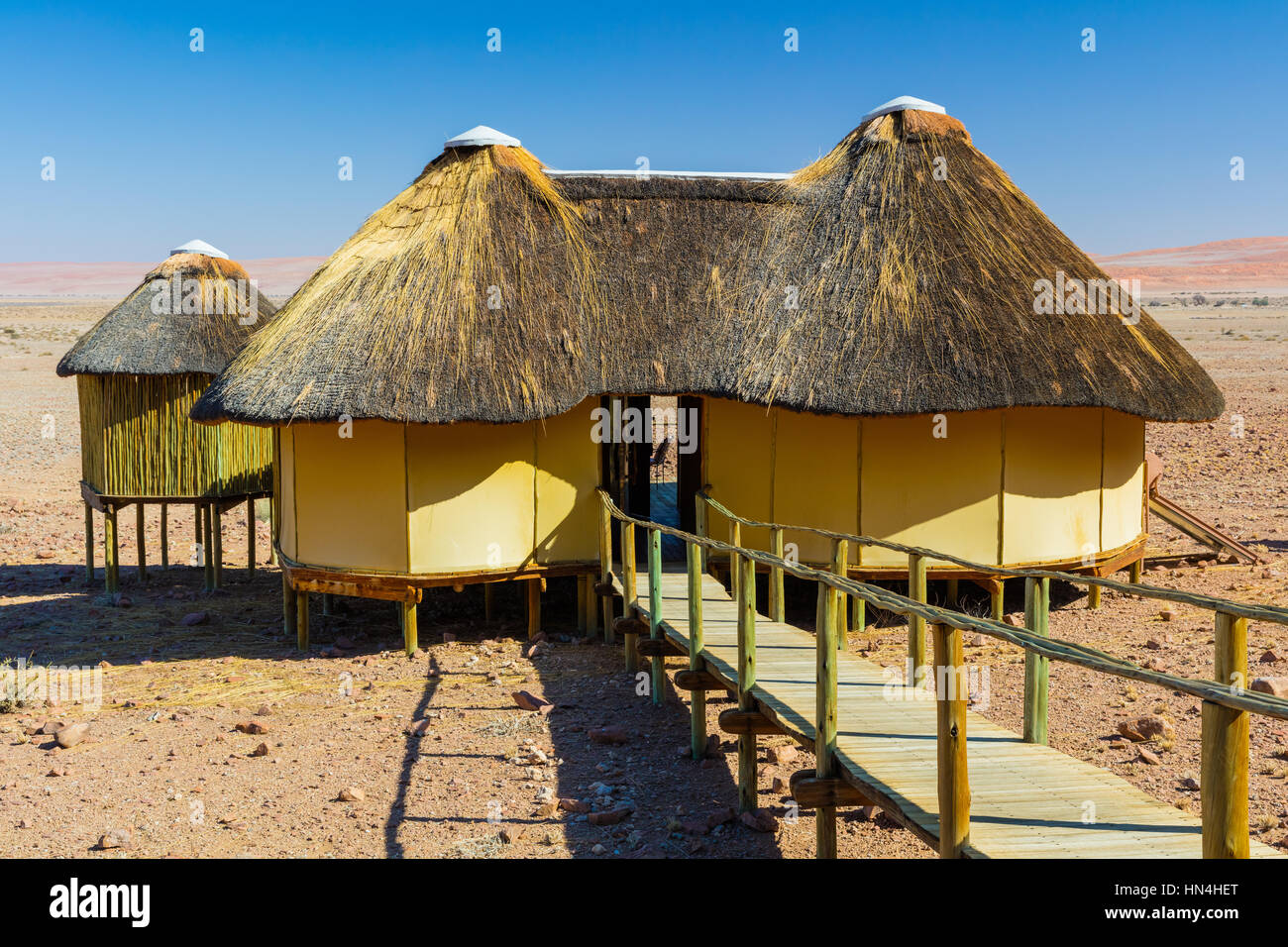 Sossus Dune Lodge liegt gegen die tief liegenden Berge in der Namib-Naukluft-Nationalpark in Namibia. Stockfoto