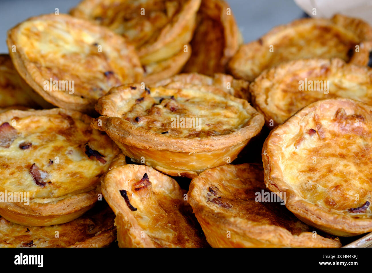 Ein Haufen von frische, handgemachte, individuelle Quiches (Ei und Speck Kuchen) auf dem display Stockfoto