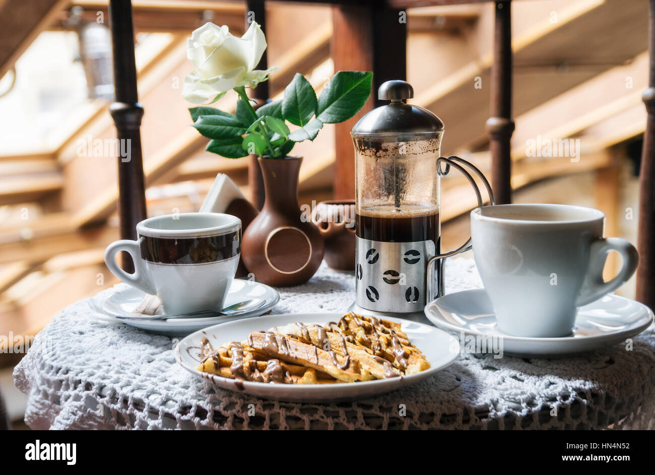 Zwei Tassen Kaffee und Waffeln mit Schokolade. Das traditionelle Frühstück. Stockfoto