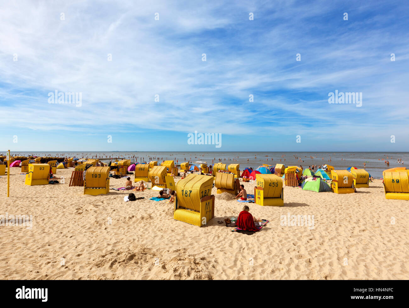 Cuxhaven, Deutschland - 18. August 2012: Menschen, die am heißesten Tag des Jahres am Strand von Duhnen mit seinen gelben Liegestühle genießen. Stockfoto
