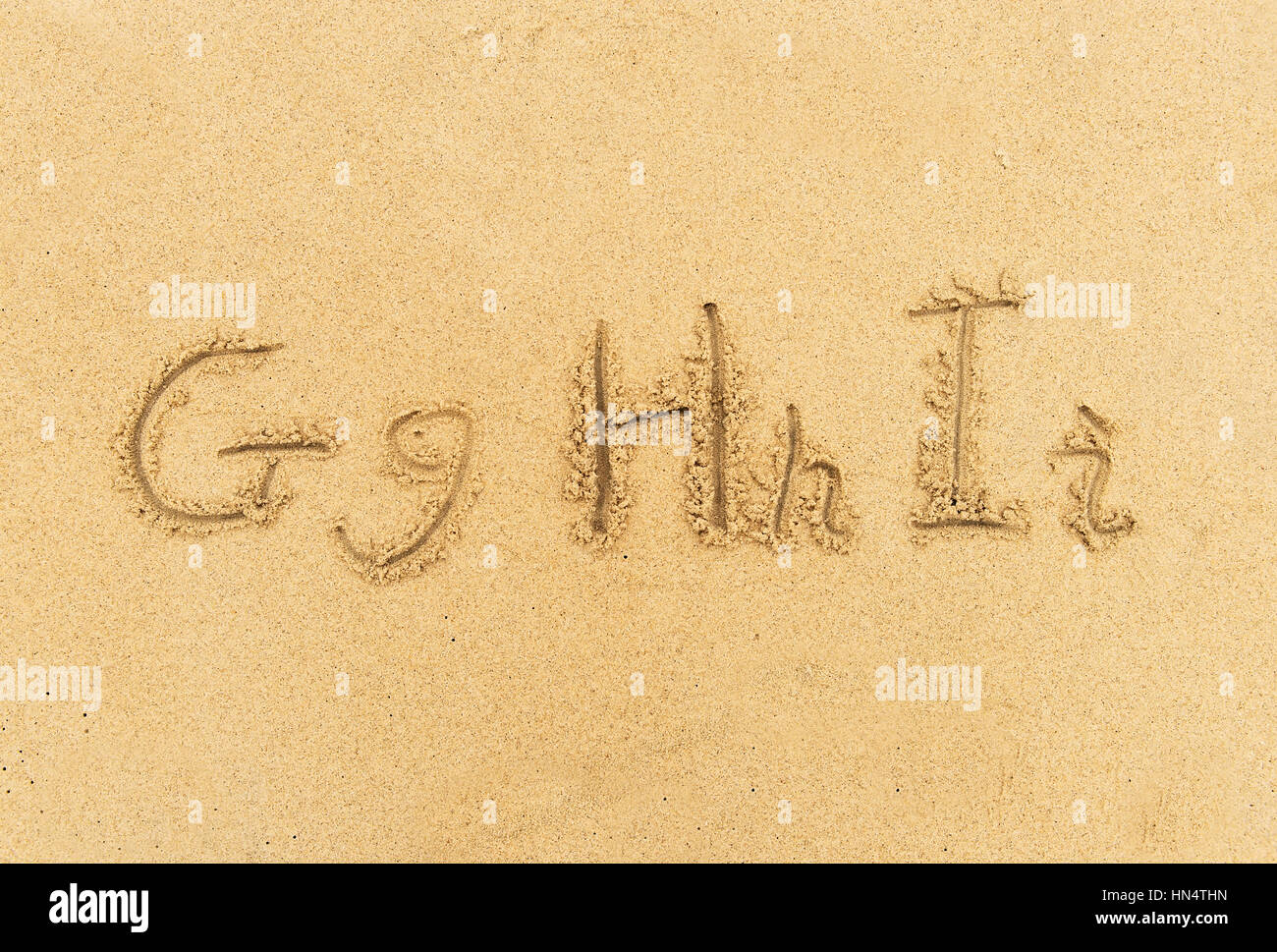 Alphabet Buchstaben handschriftlich im Sand am Strand Stockfoto
