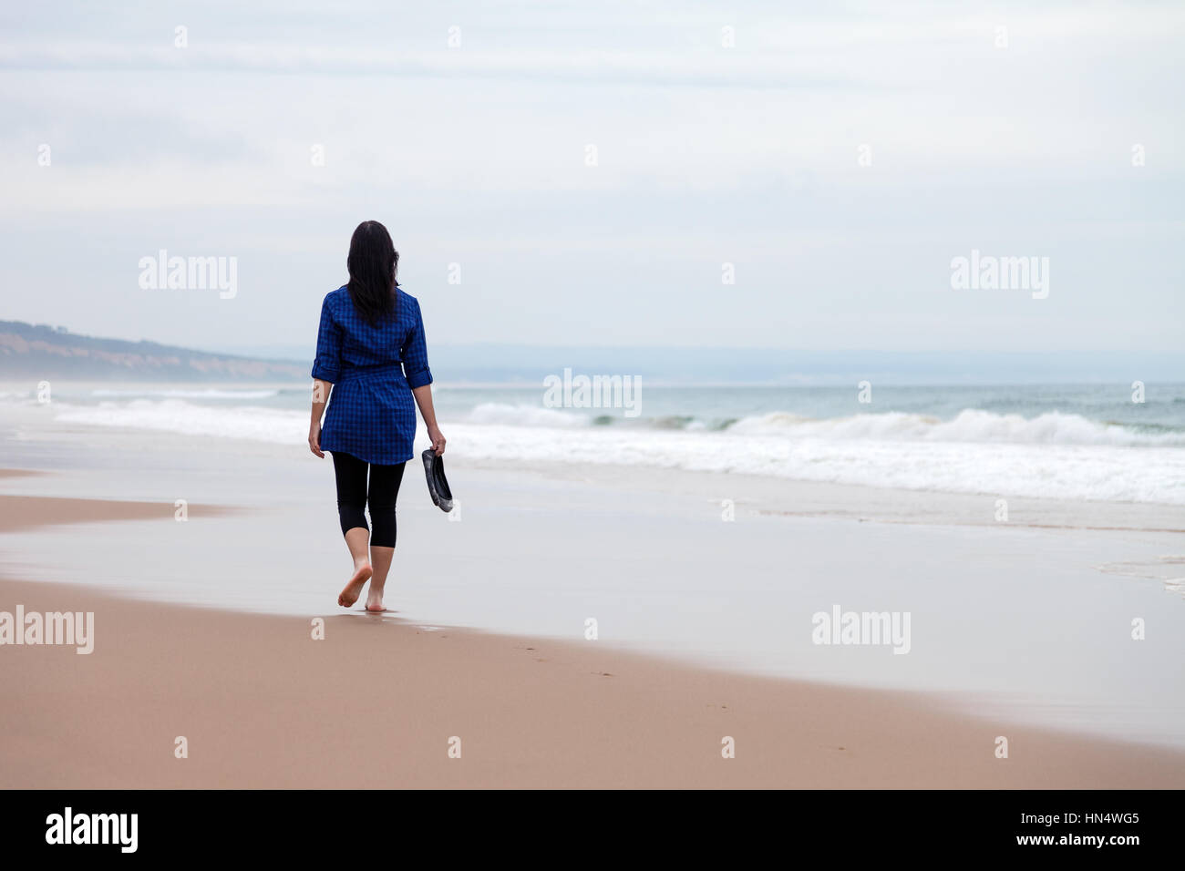 Junge Frau Weg alleine in einer verlassenen Strand auf einen Herbst Tag-/frau Strand allein einsame traurige Traurigkeit Depression depressiv verliebt Stockfoto