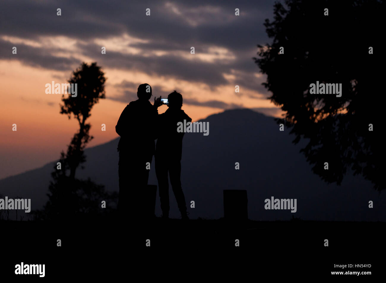 Zwei Wanderer nehmen Bild mit Ihrem Smartphone in die Berge bei Sonnenuntergang Stockfoto