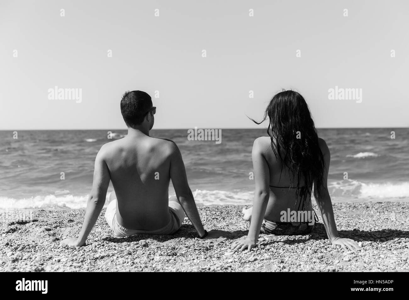 Paar sitzt wieder am Ufer des Meeres Stockfoto