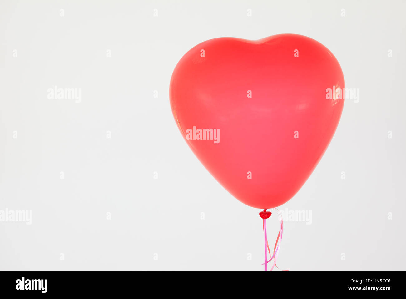 Herzförmige rote Ballon vor weißem Hintergrund Stockfoto