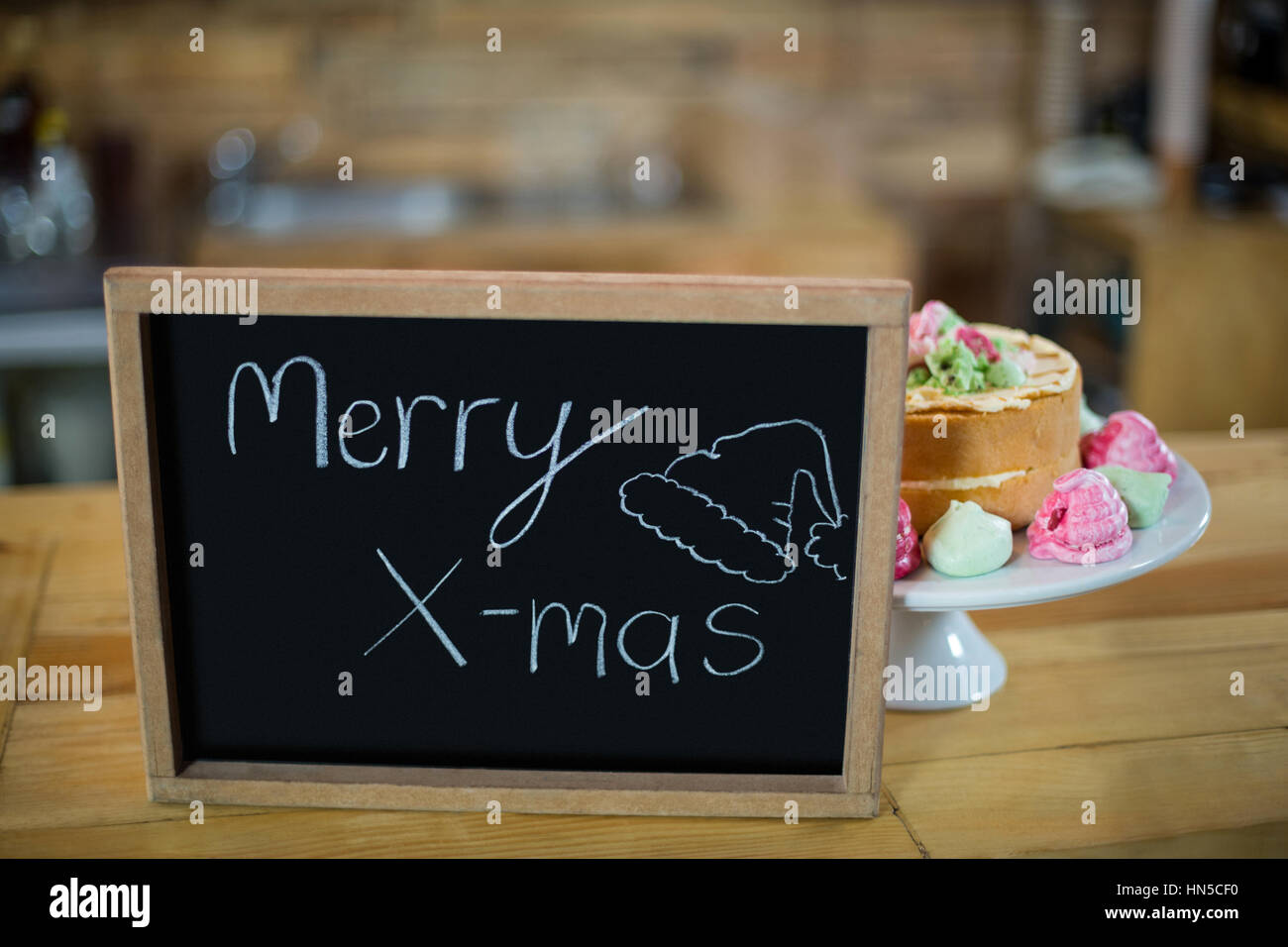 Merry X-Mas-Schild mit Kuchen am Schalter im CafÃƒÂ © Stockfoto