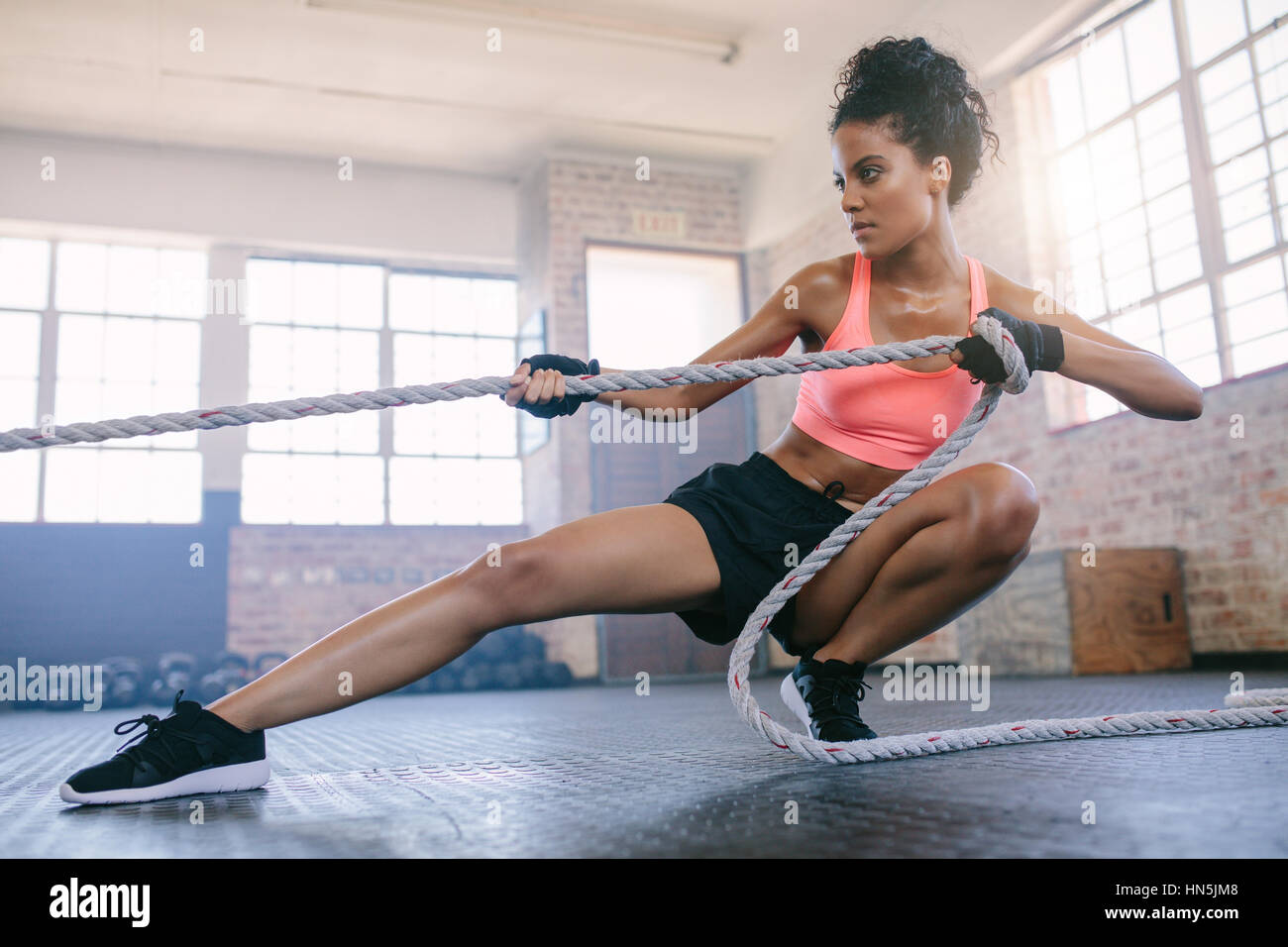 Aufnahme des jungen Fitness weiblichen Turnen mit Seil in einem  Fitnessstudio. Junge Frau am Gym Seil ziehen Stockfotografie - Alamy