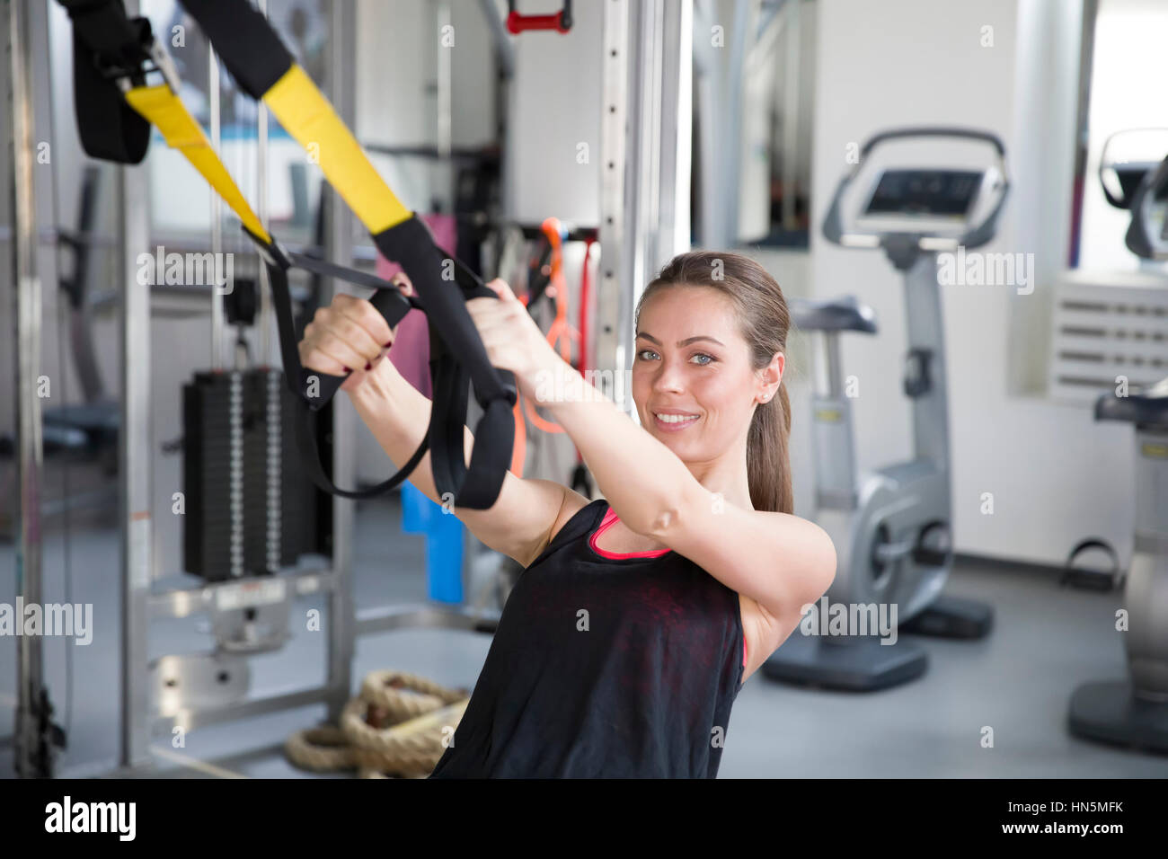 Frauen tun Push ups Training Arme mit Trx-Fitness-Trägern in der Turnhalle Stockfoto