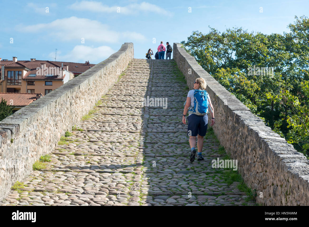 Frau Tourist geht über die römische Brücke von Cangas de Onis eine alte über den Fluss Sella in den Picos de Europa-Spanien Steinbrücke Stockfoto