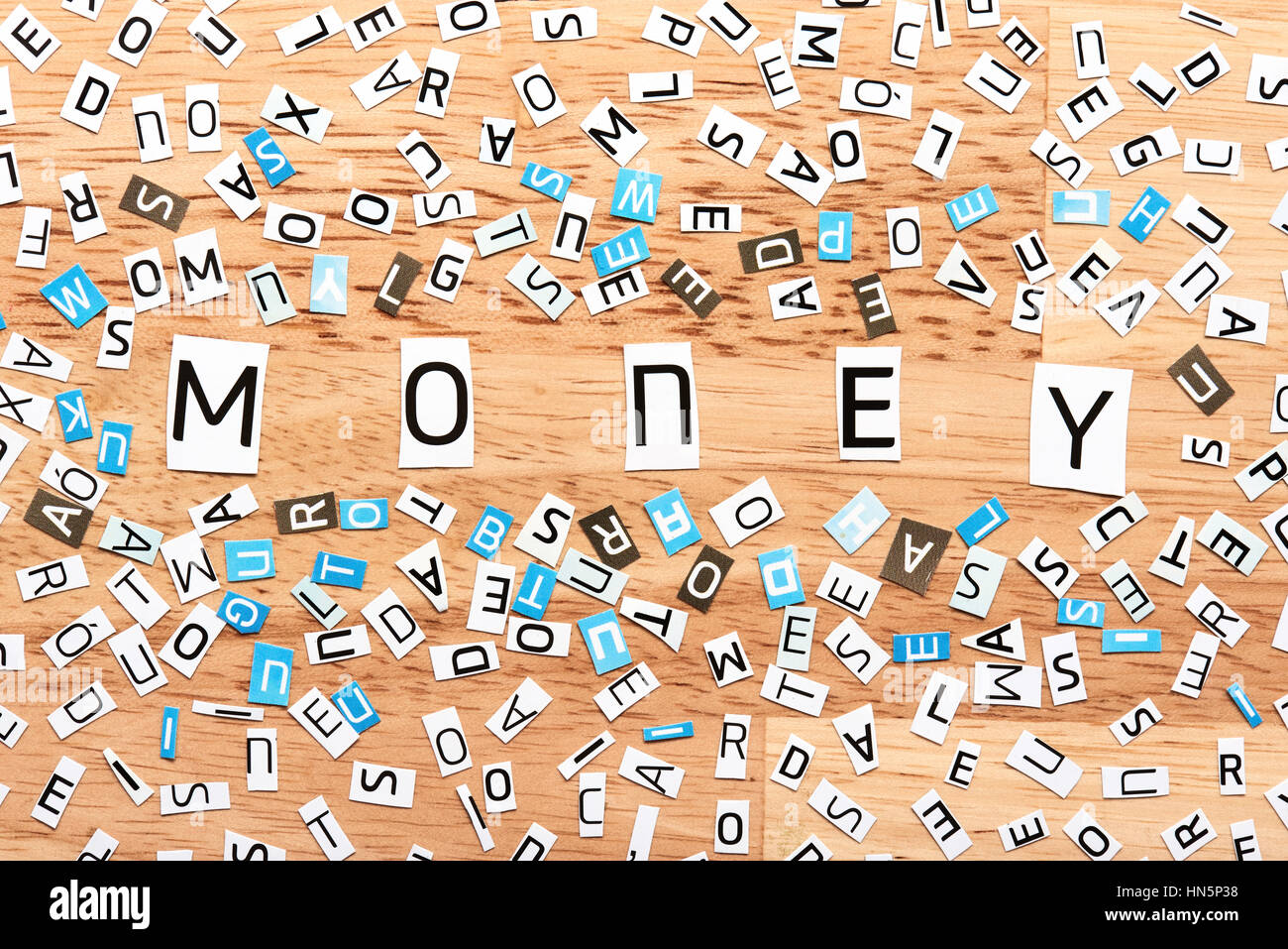 Geld das Wort Ausschneiden von Buchstaben auf Holztisch Stockfoto