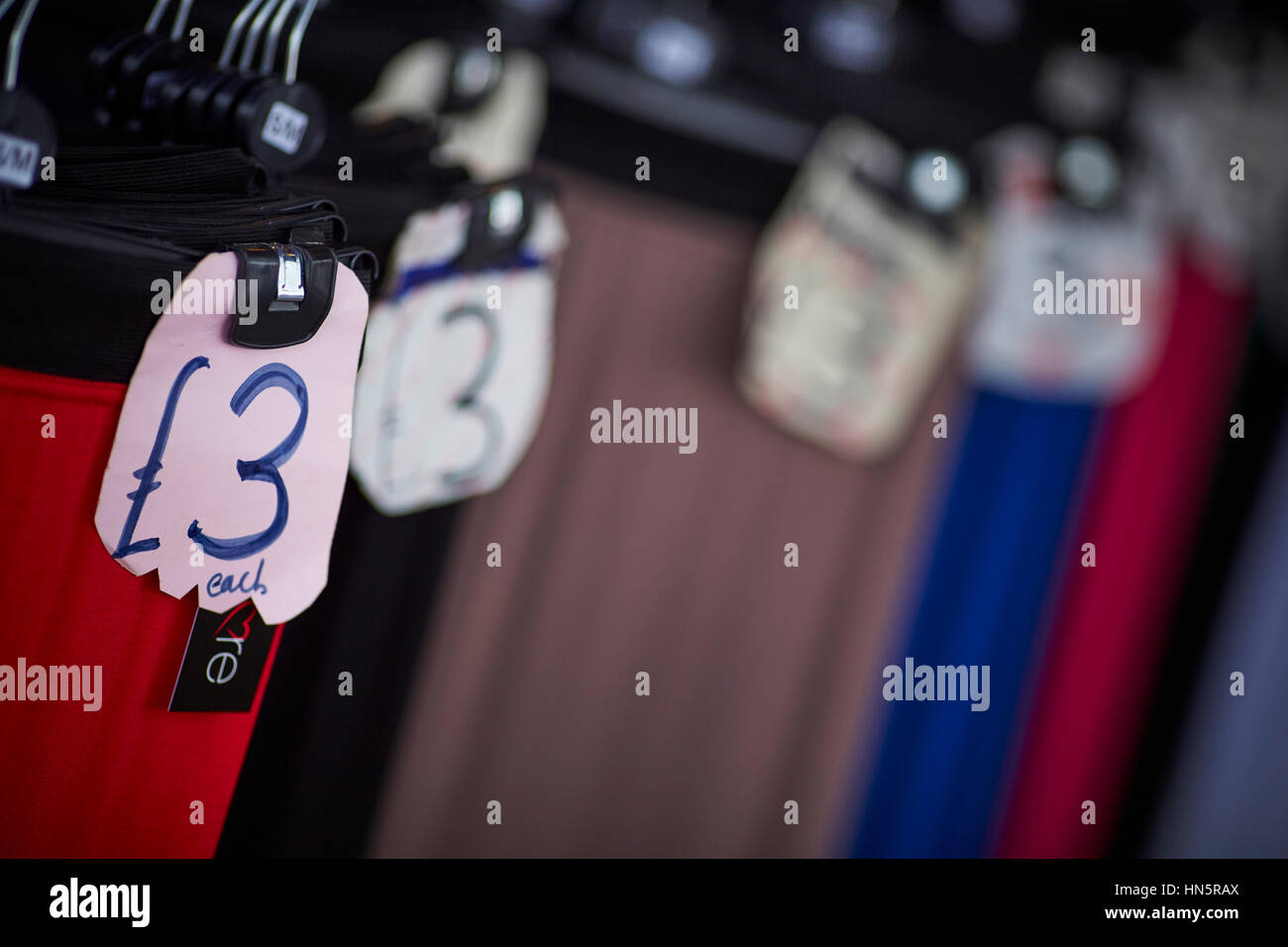 Billig zu kleiden und £3 Pfund-Zeichen auf einem Markt hängen stall unabhängige Einzelhändler auf Longsight Markt Manchester, England, UK Stockfoto