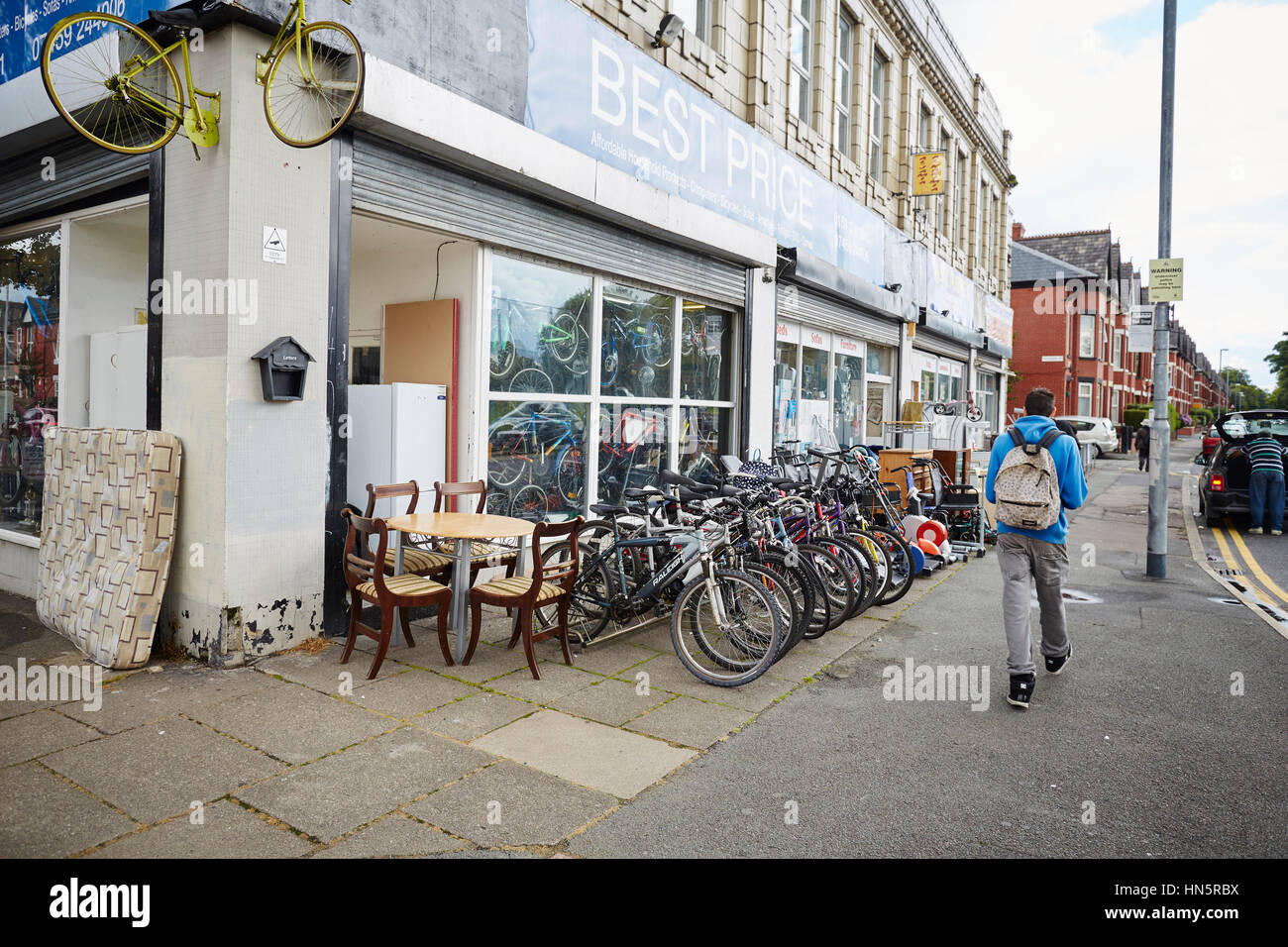 Exterieur des besten Preises ein Second-Hand-Junk-e-Shop mit Fahrräder und Möbel auf dem Display auf dem Bürgersteig auf Platt Lane, Manchester, England, UK. Stockfoto