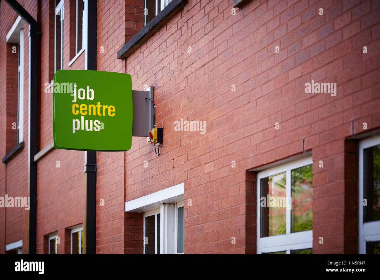 Grüne Schild an der Außenarchitektur Wand des Job Centre Plus Tür Eingang außerhalb des Büros von Dole im Didsbury, South Manchester, England, UK. Stockfoto