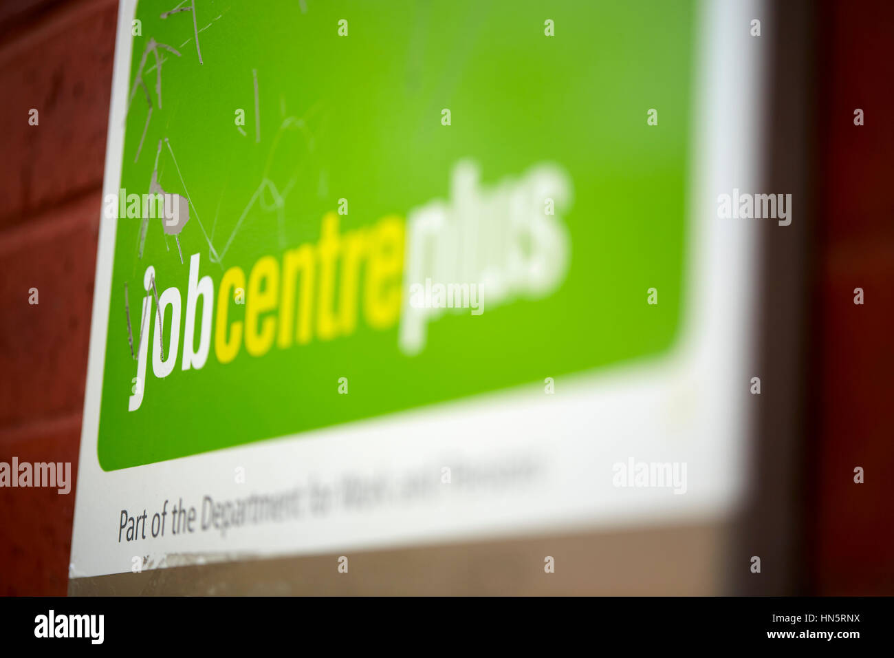 Grüne Schild an der Außenarchitektur Wand des Job Centre Plus Tür Eingang außerhalb des Büros von Dole im Didsbury, South Manchester, England, UK. Stockfoto