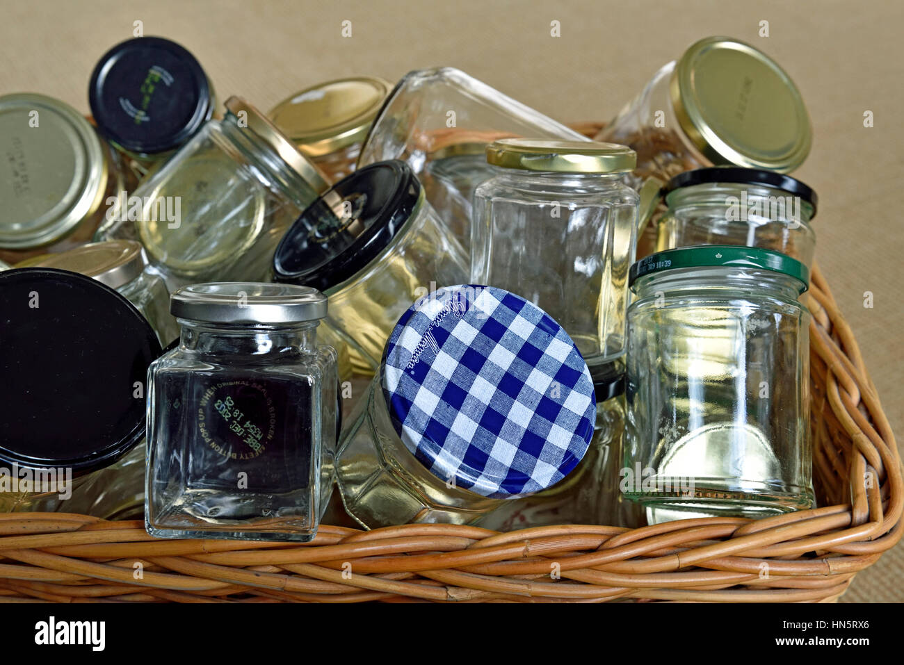 Leere Glasgefäße mit Deckeln in einem gewaschenen Korb, bereit für Wiederverwendung, Lagerung oder Recycling. Stockfoto