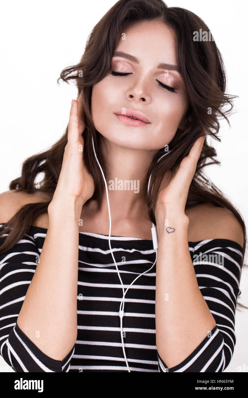 Schöne Frau mit gesunde Haut, Haare locken und Kopfhörer, posiert im Studio. Beauty Gesicht. Stockfoto