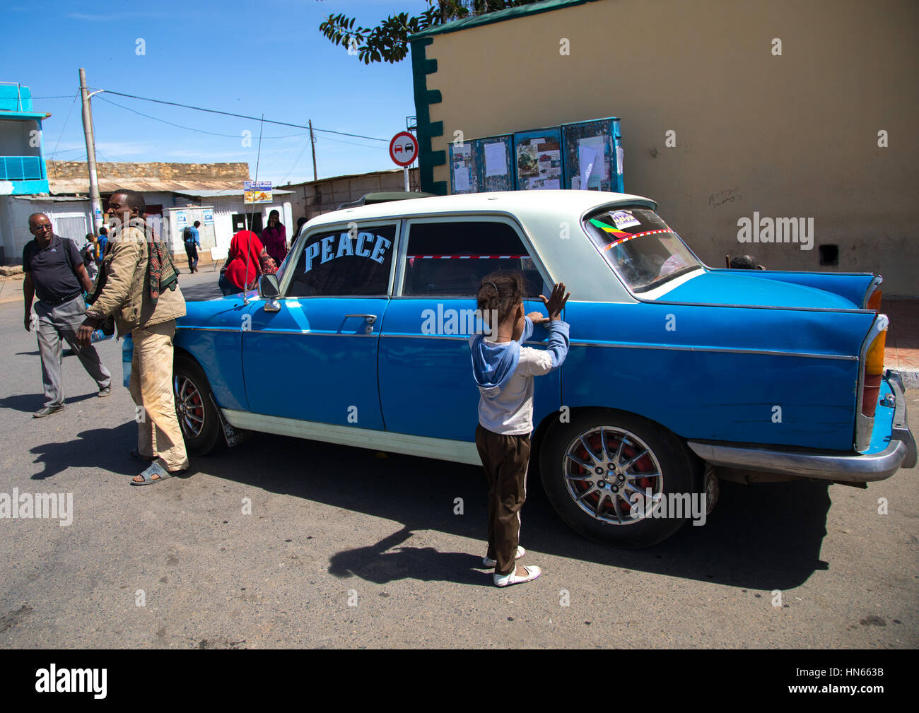 Kind Oeping die Tür von einem alten Peugeot 404 Taxi, Harari Region Harar, Äthiopien Stockfoto
