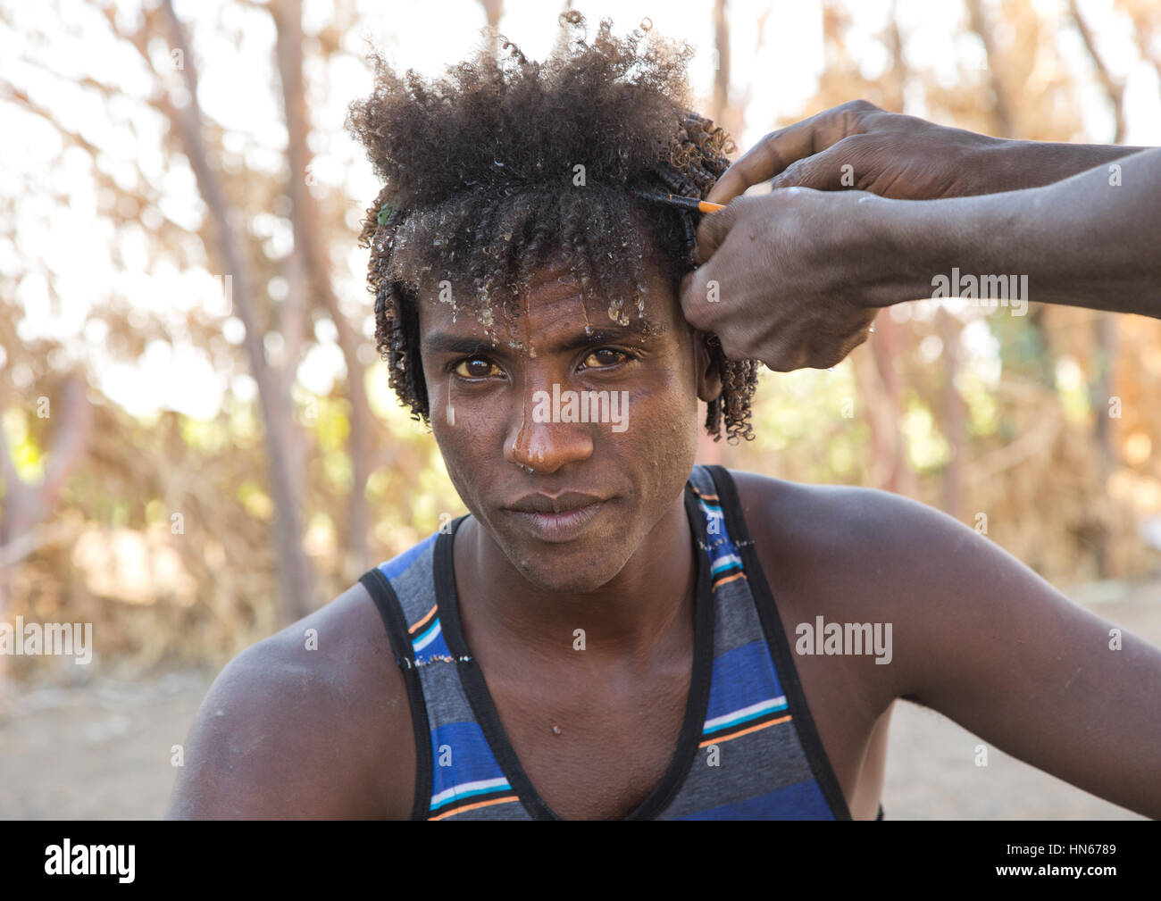 Der Ferne Mann mit einem traditionellen Frisur mit einem Stock zu lockiges Haar, Afar-Region, Afambo, Äthiopien Stockfoto