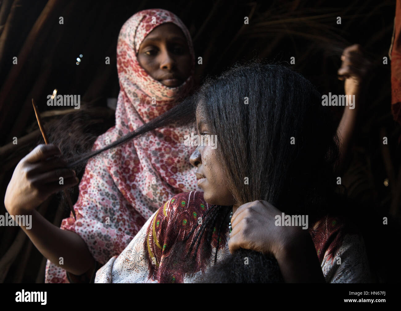Ferne Frau, die eine traditionelle Frisur in ihrer Hütte, Afar Region, Afambo, Äthiopien Stockfoto