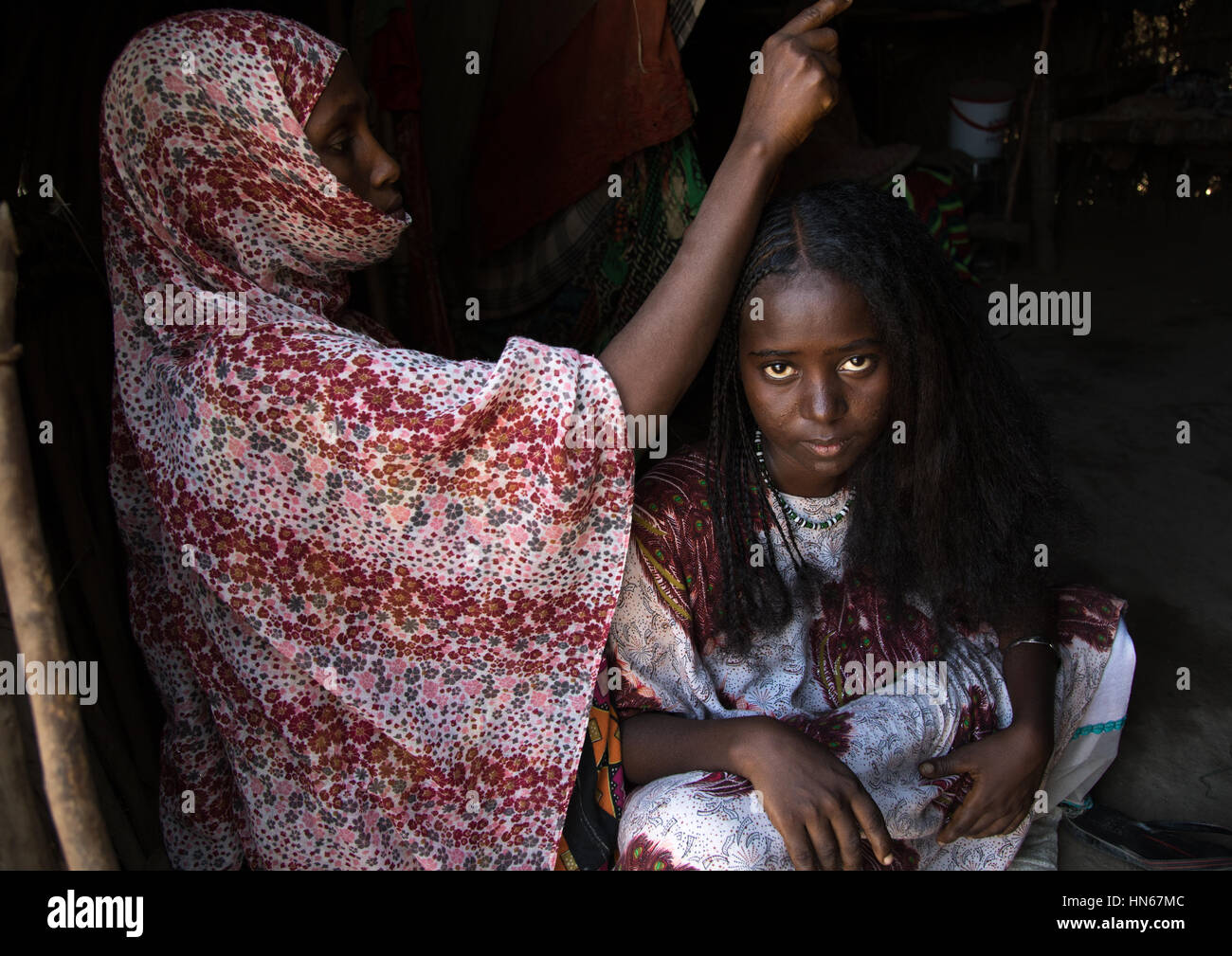 Ferne Frau, die eine traditionelle Frisur in ihrer Hütte, Afar Region, Afambo, Äthiopien Stockfoto