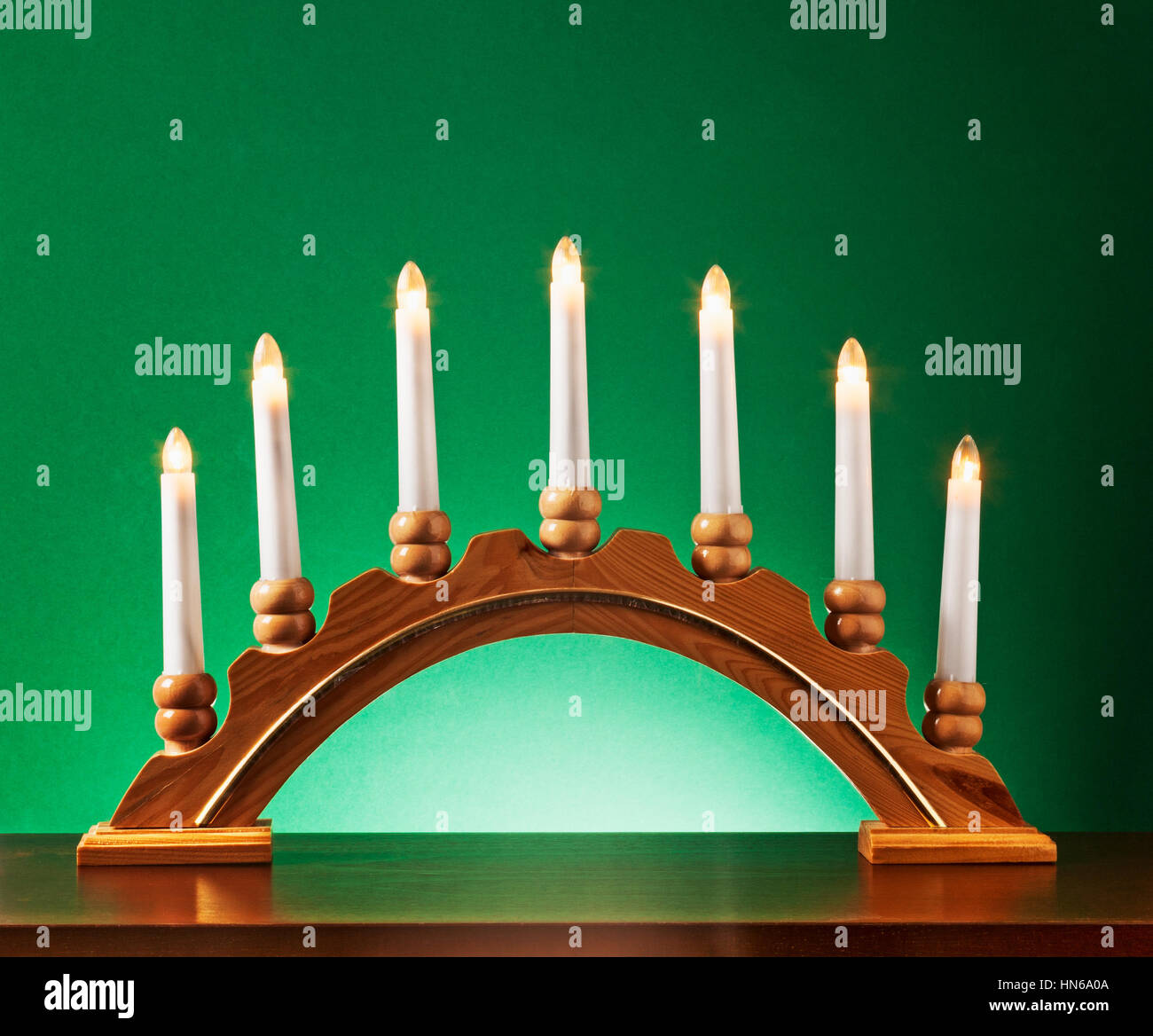Weihnachten-Holz-Kerze-Halter mit Glühbirnen auf grünem Hintergrund, Beleuchtung und Dekoration für die Adventszeit Stockfoto