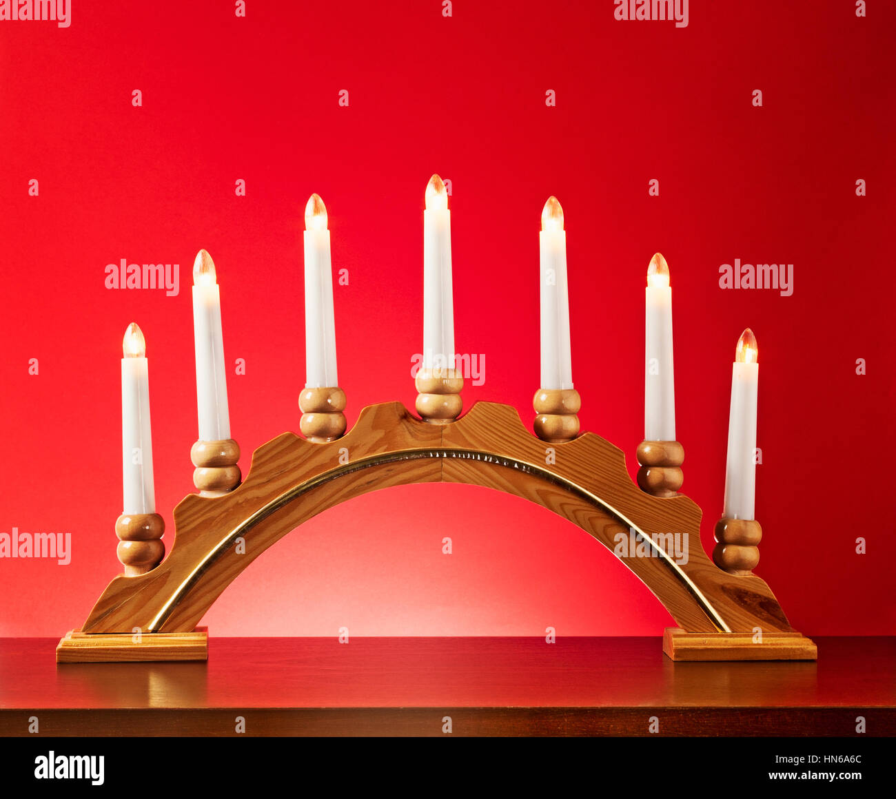 Weihnachten-Holz-Kerze-Halter mit Glühbirnen auf rotem Hintergrund, Beleuchtung und Dekoration für die Adventszeit Stockfoto