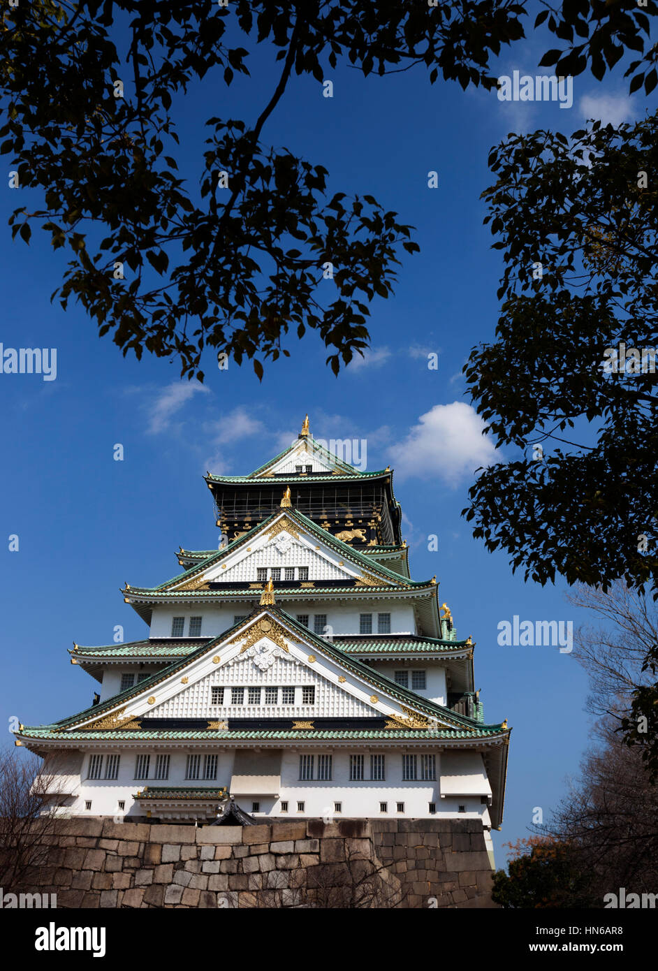 OSAKA, JAPAN - März 14: Die wichtigsten Turm von Osaka Castle umrahmt von Bäumen im Schlosspark in Osaka, Japan am 14. März 2012. Das Gebäude ist ein c Stockfoto