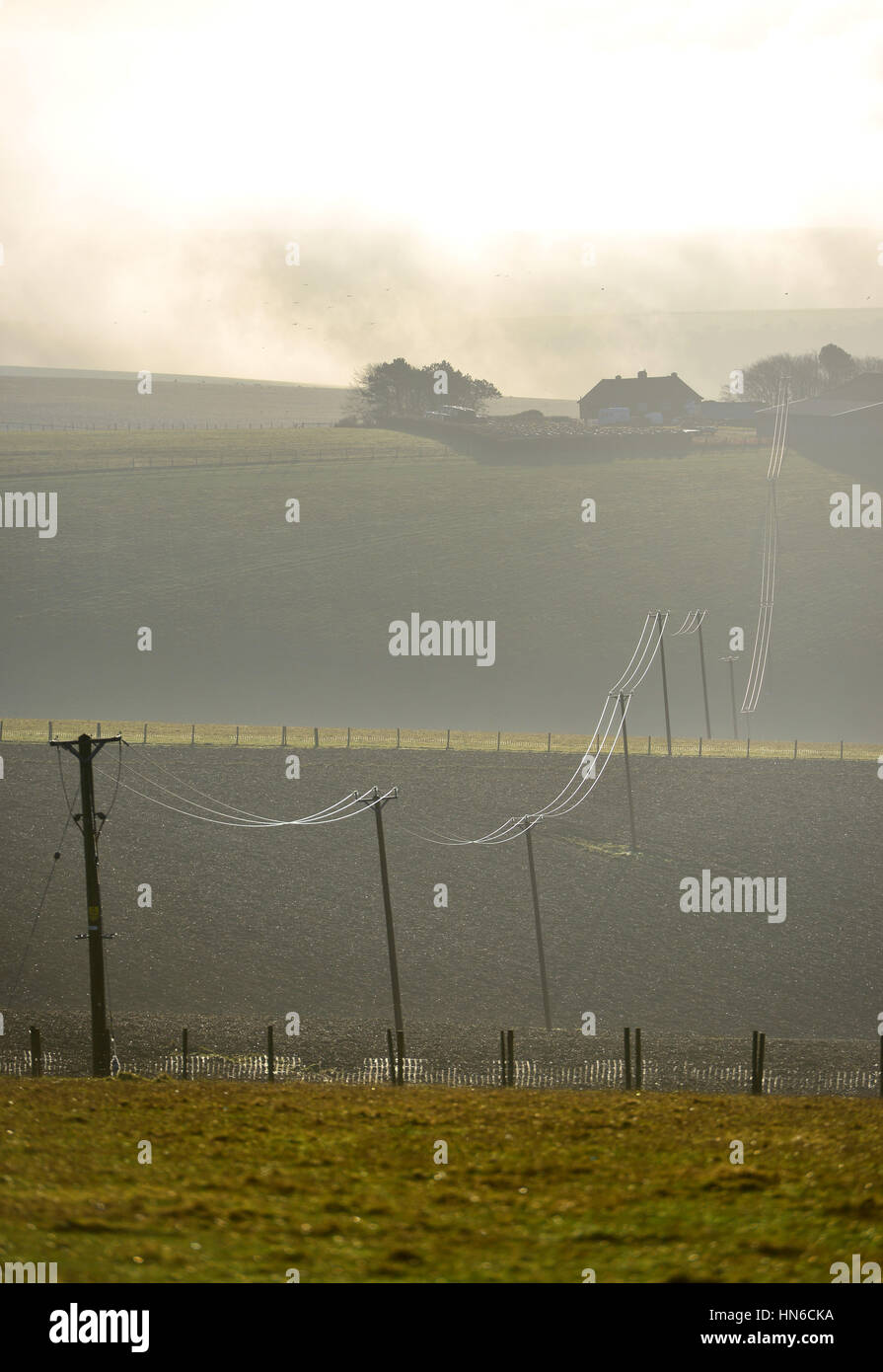 Stromleitungen, die Verknüpfung von eines kleinen abgelegenen Bauernhof an das nationale Stromnetz, South Downs National Park in East Ssussex Stockfoto