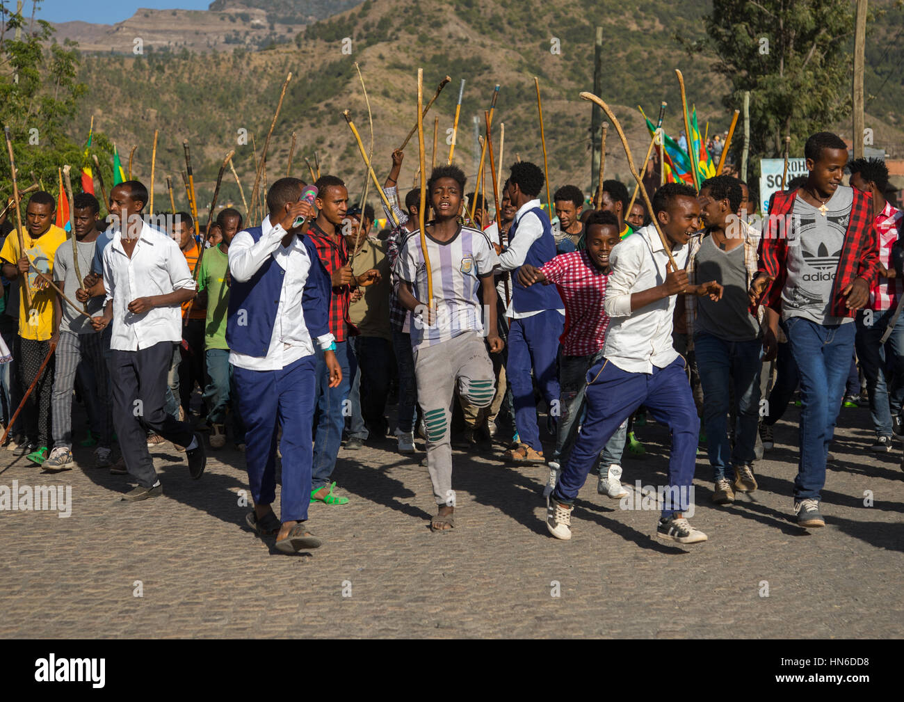 Äthiopischen jungen Männer tanzen und singen auf der Straße mit Stöcken während Timkat Epiphanie Festival, Amhara Region, Lalibela, Äthiopien Stockfoto