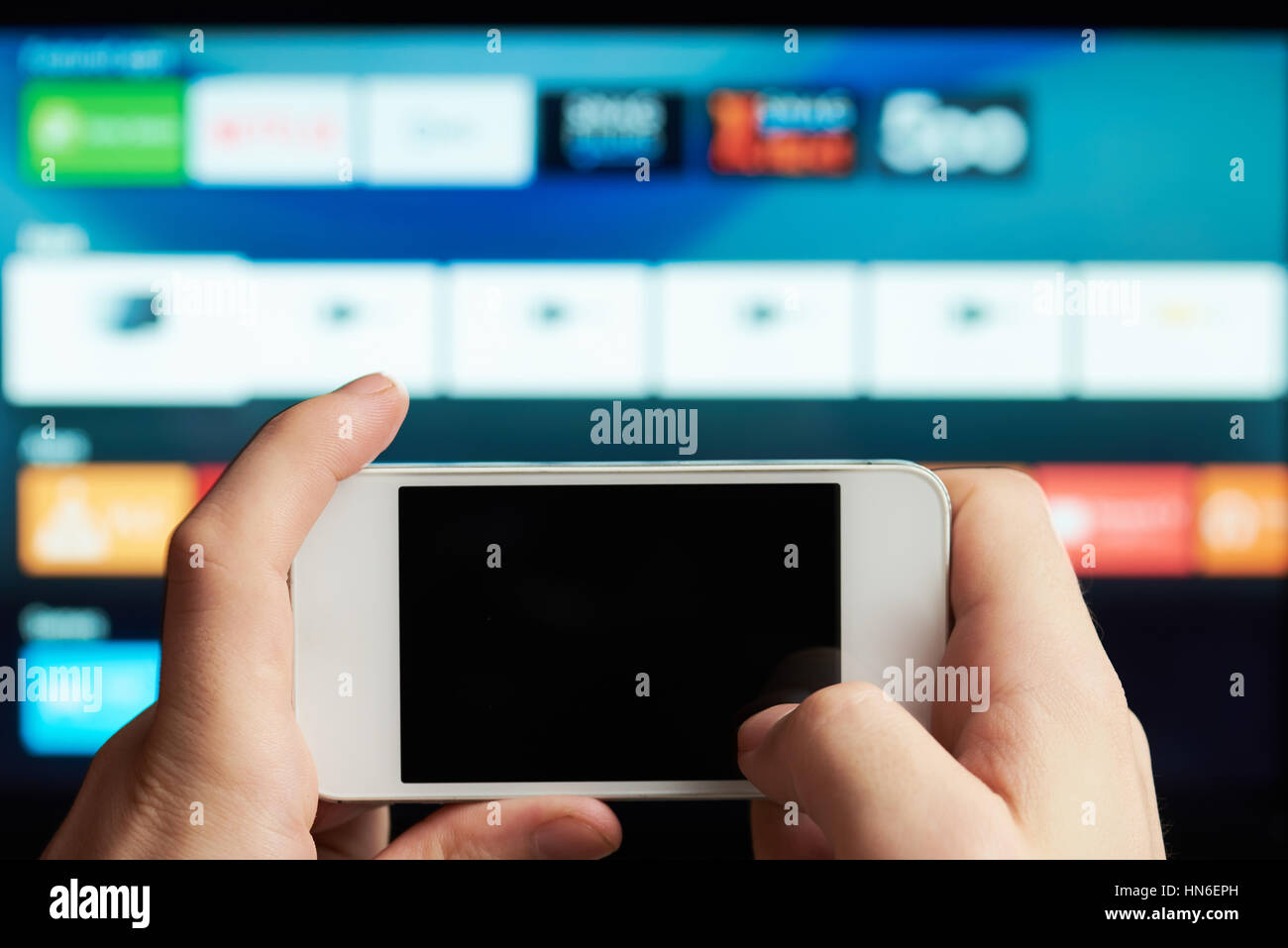 Nahaufnahme von Smartphone als Fernbedienung von smart tv Stockfoto