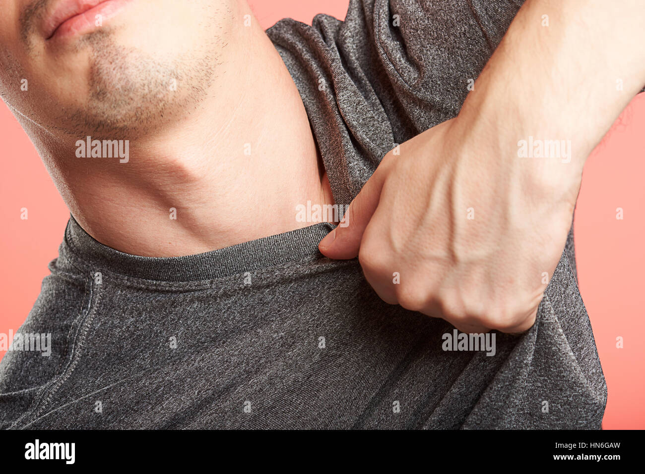 Nahaufnahme von Hand packte Mann Hemd auf rosa Hintergrund Stockfoto