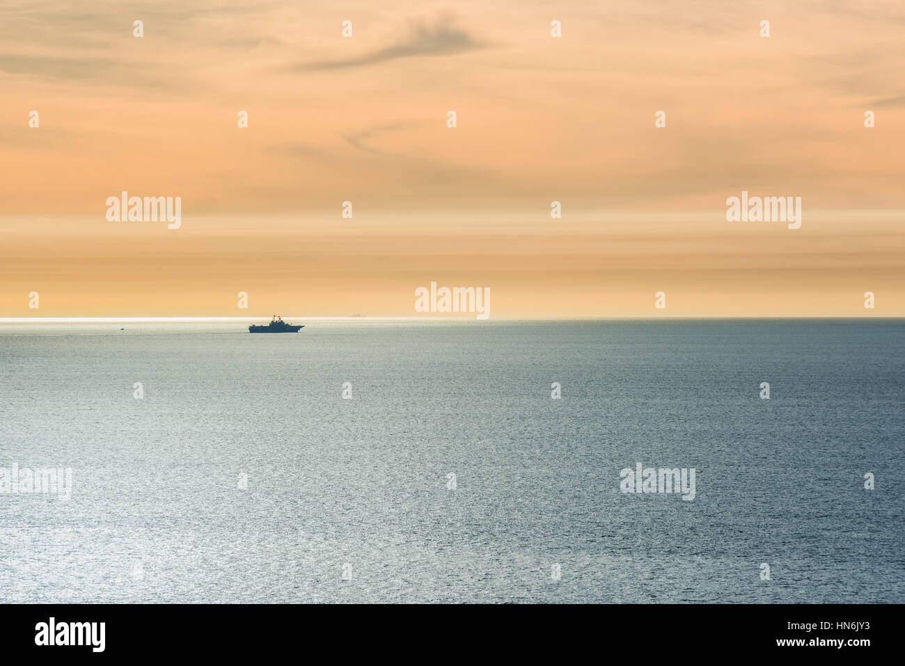 Ein Schiff, das im Pazifischen Ozean mit Smog und Sonne Strahl Weg während des Sonnenuntergangs in der Nähe von San Diego, Kalifornien Stockfoto