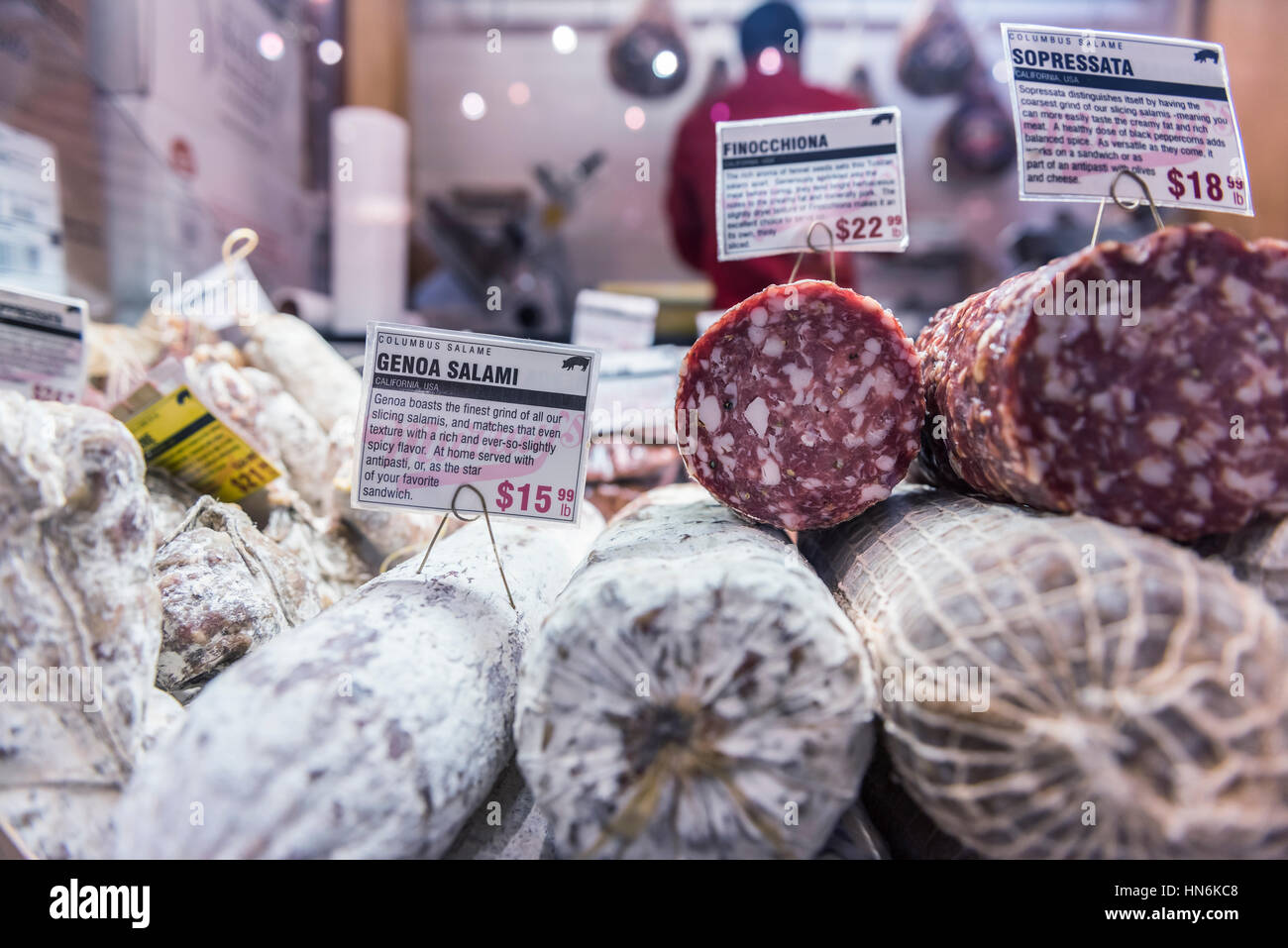 Nahaufnahme von Sopressata und Genua Salami Brötchen auf dem Display in einem Markt Geschäft mit Metzger im Hintergrund Stockfoto