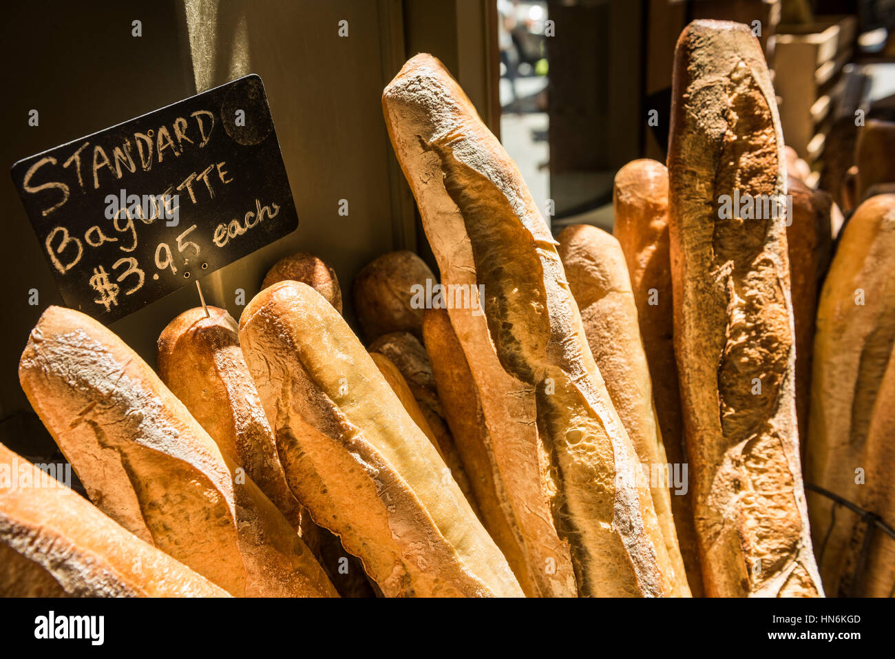 Baguettes im morgendlichen Sonnenlicht von einer Fensterbank in einer Bäckerei mit anderen Brotsorten Stockfoto